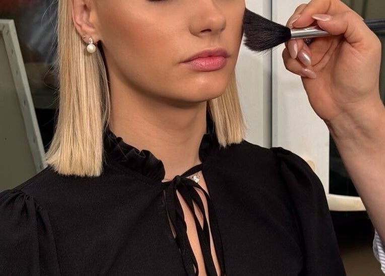 Makeup artist adds final touches at Austeya Artistry, Richmond, England, GB. Beauty perfection in progress.