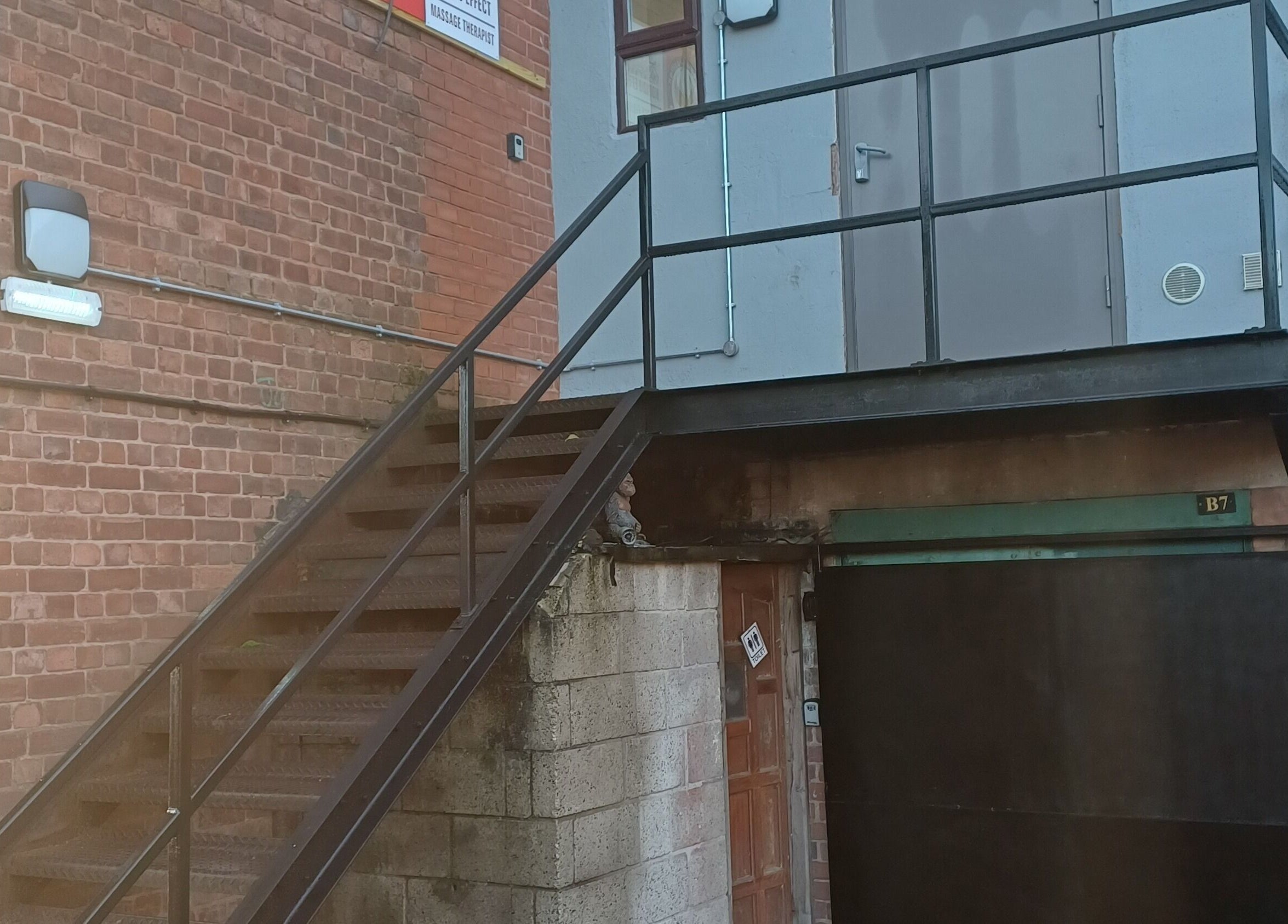 Wejście do Kobido Effect w Mansfield, Anglia, GB z metalowymi schodami i ceglaną ścianą.