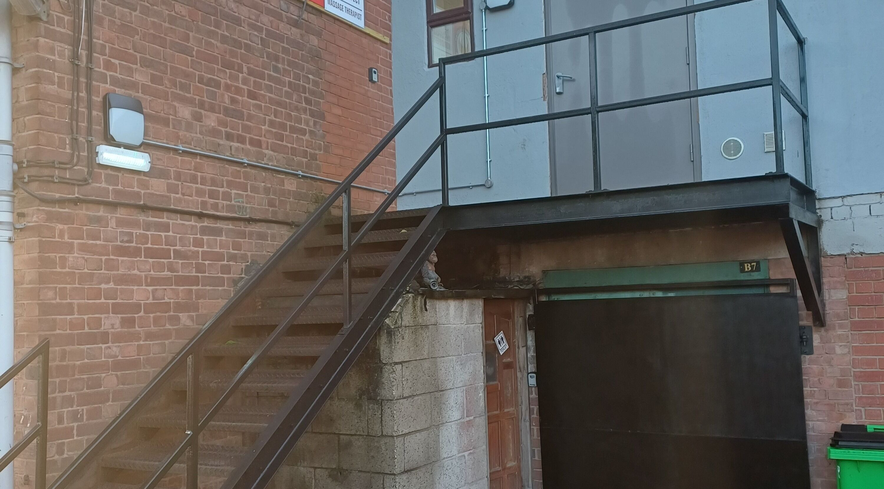Wejście do Kobido Effect w Mansfield, Anglia, GB z metalowymi schodami i ceglaną ścianą.