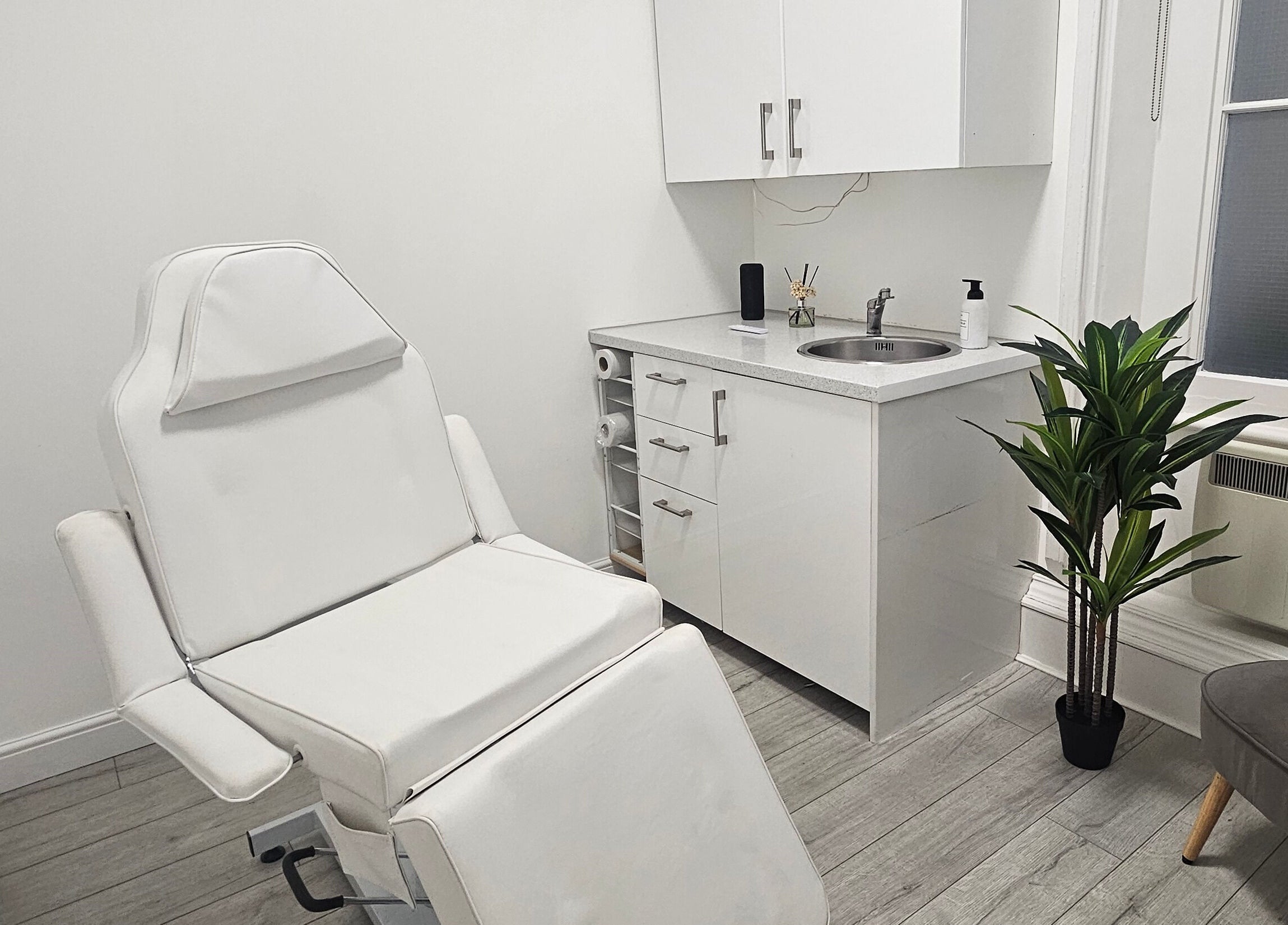 Sleek treatment room at Rep Studio, London, England, GB featuring a modern chair and minimalist decor.