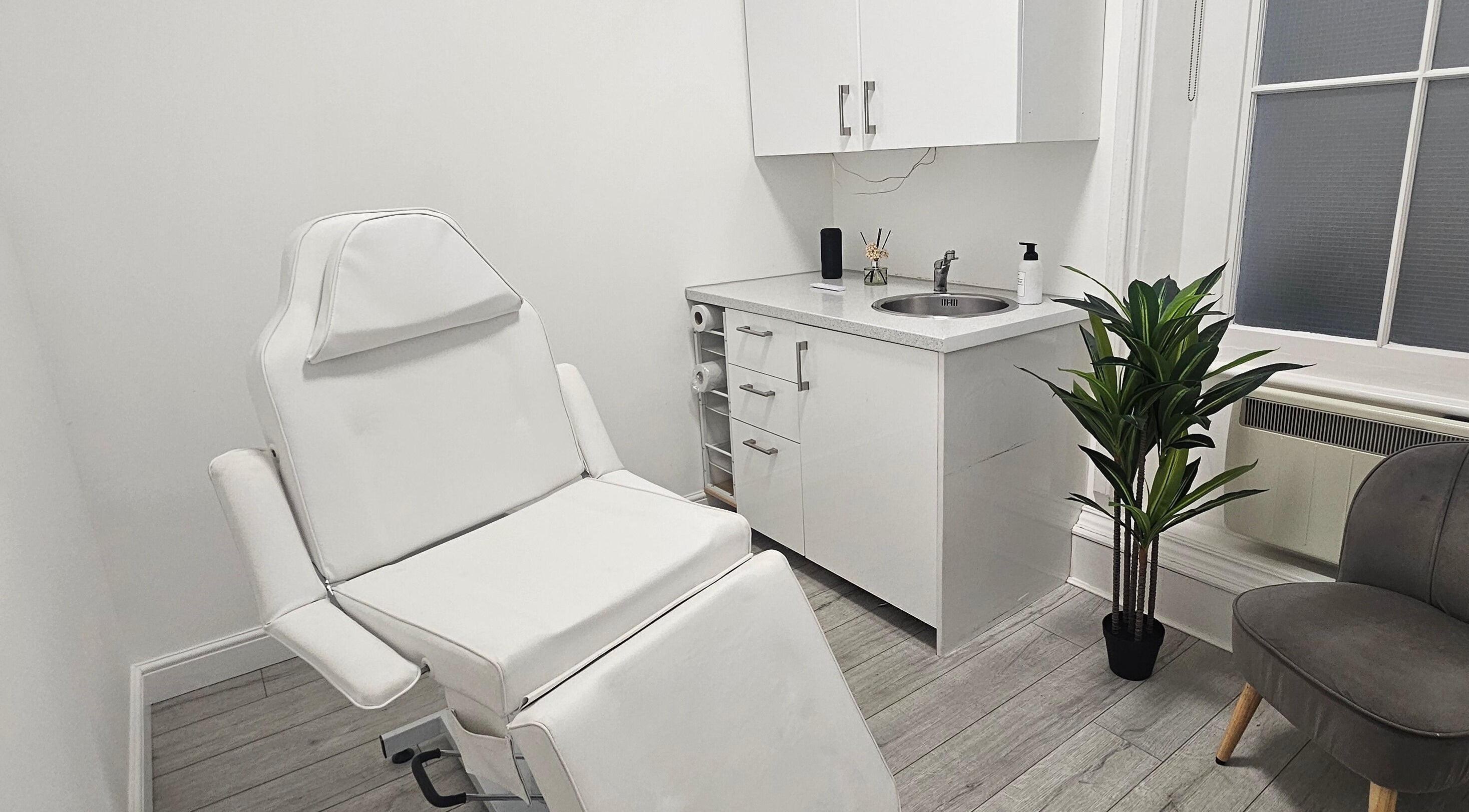 Sleek treatment room at Rep Studio, London, England, GB featuring a modern chair and minimalist decor.