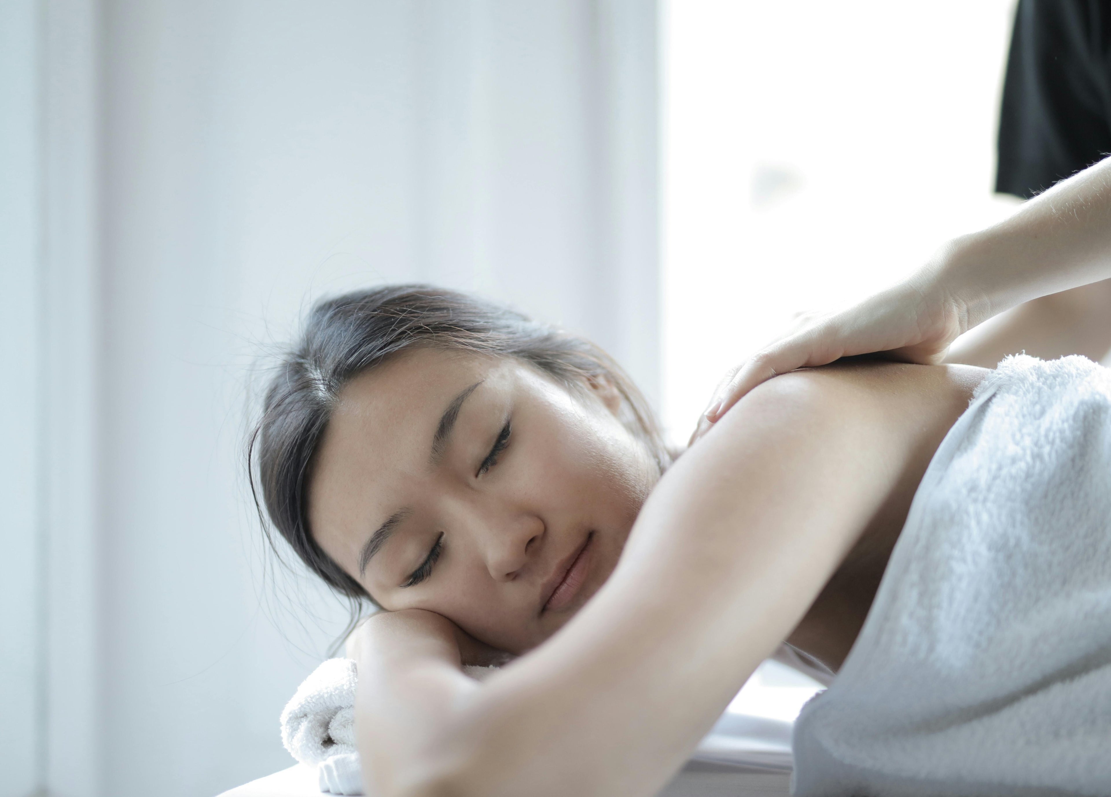 Person enjoying a massage at Rep Studio, London, England, GB, highlighting tranquility and wellness.