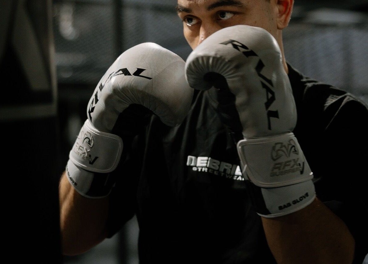 A boxer in white gloves training at Team Igusti, Hindmarsh, South Australia, AU.