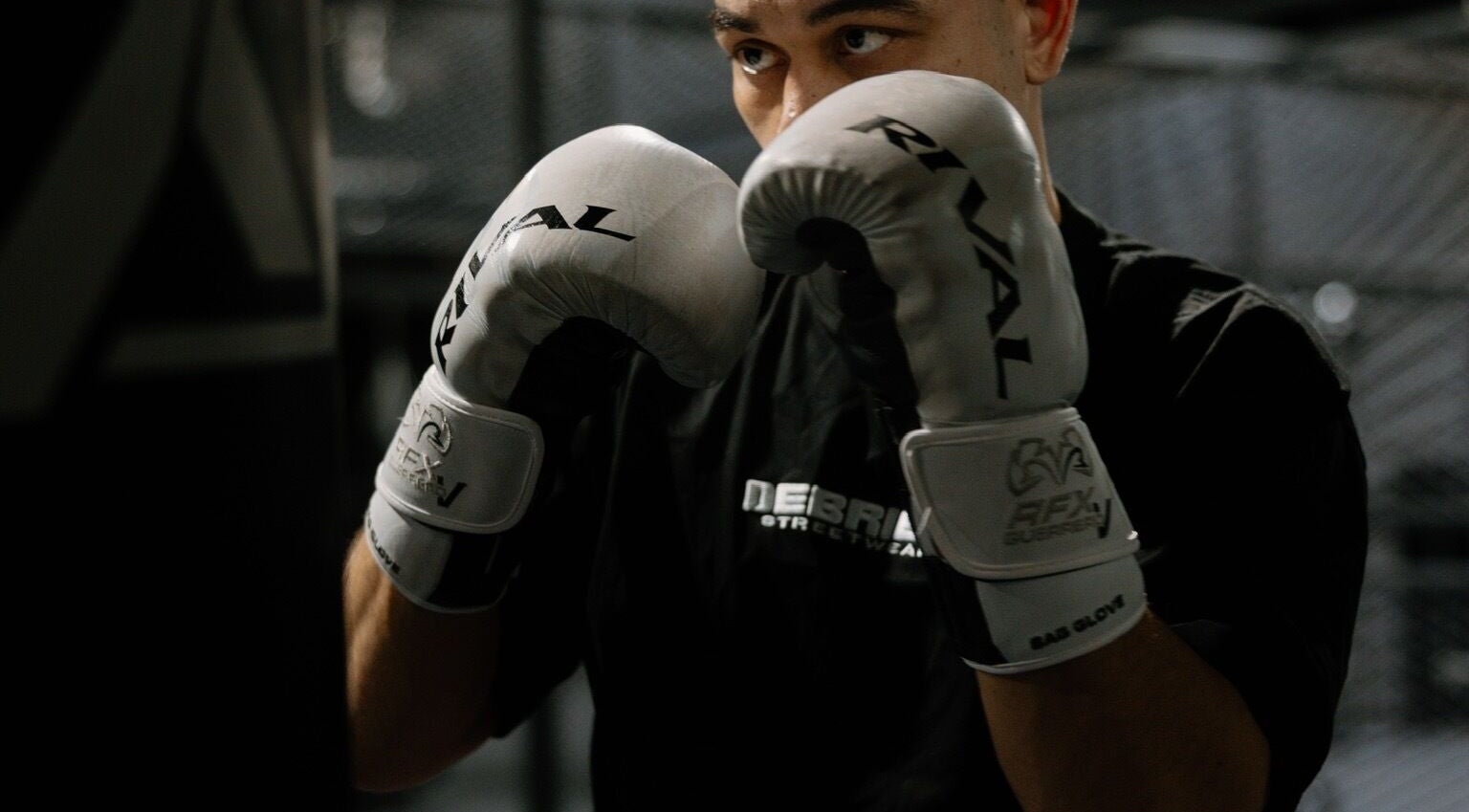 A boxer in white gloves training at Team Igusti, Hindmarsh, South Australia, AU.