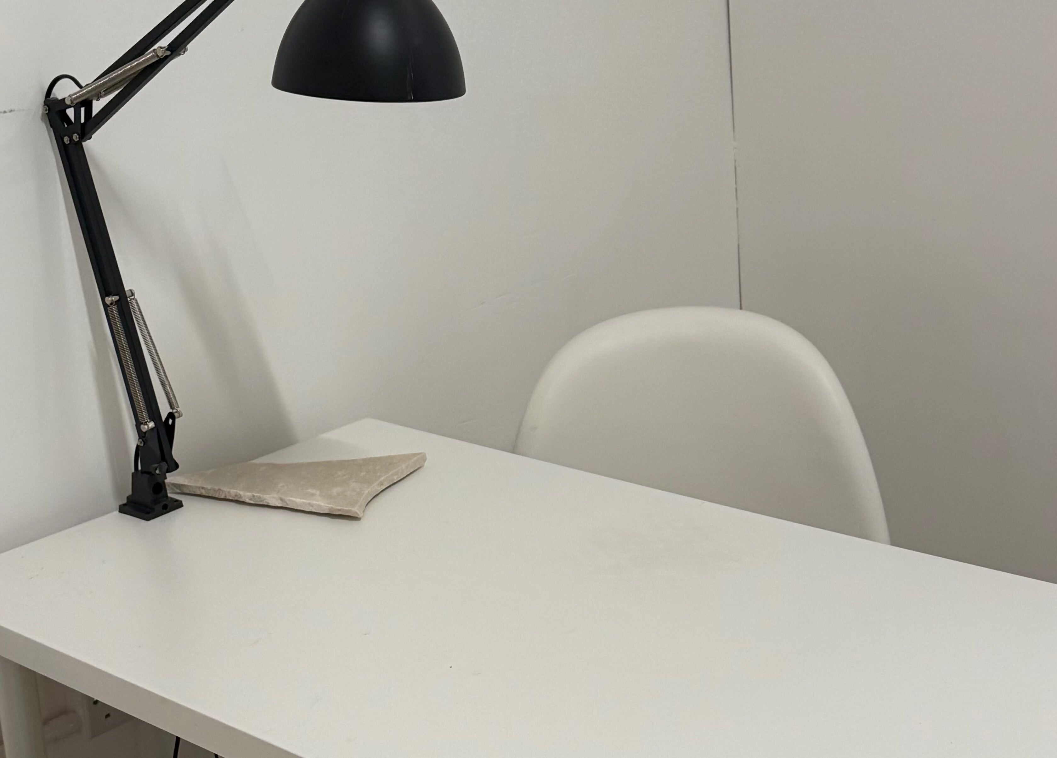 Modern minimalist workspace at Bymiaf in Salford, England. Features sleek desk with lamp.