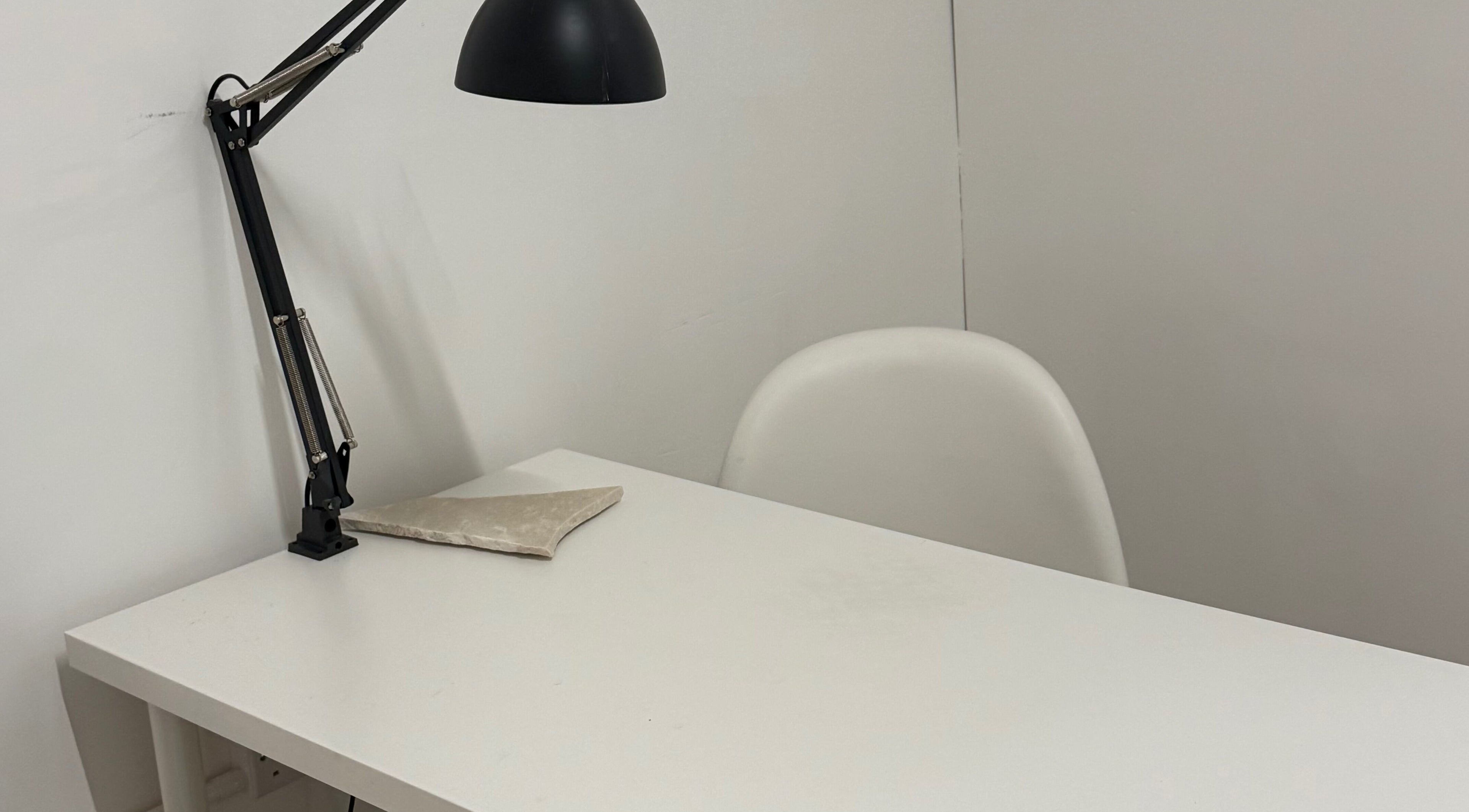 Minimalist desk setup with lamp at Bymiaf, Salford, England, GB, ideal for focused beauty and wellness sessions.