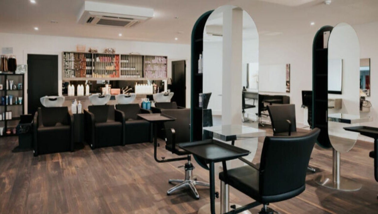 Modern salon interior at Hair by Jurgita, Killarney, County Kerry, IE, featuring stylish workstations and sleek chairs.