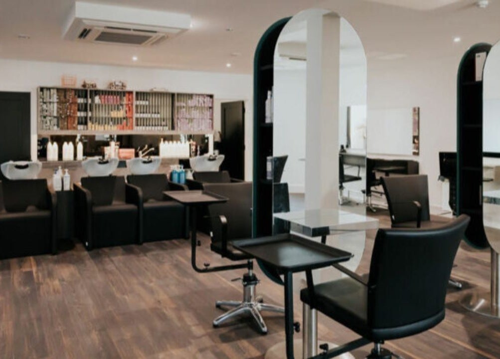 Modern salon interior at Hair by Jurgita, Killarney, County Kerry, IE, featuring stylish workstations and sleek chairs.