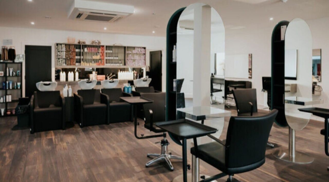 Modern salon interior at Hair by Jurgita, Killarney, County Kerry, IE, featuring stylish workstations and sleek chairs.