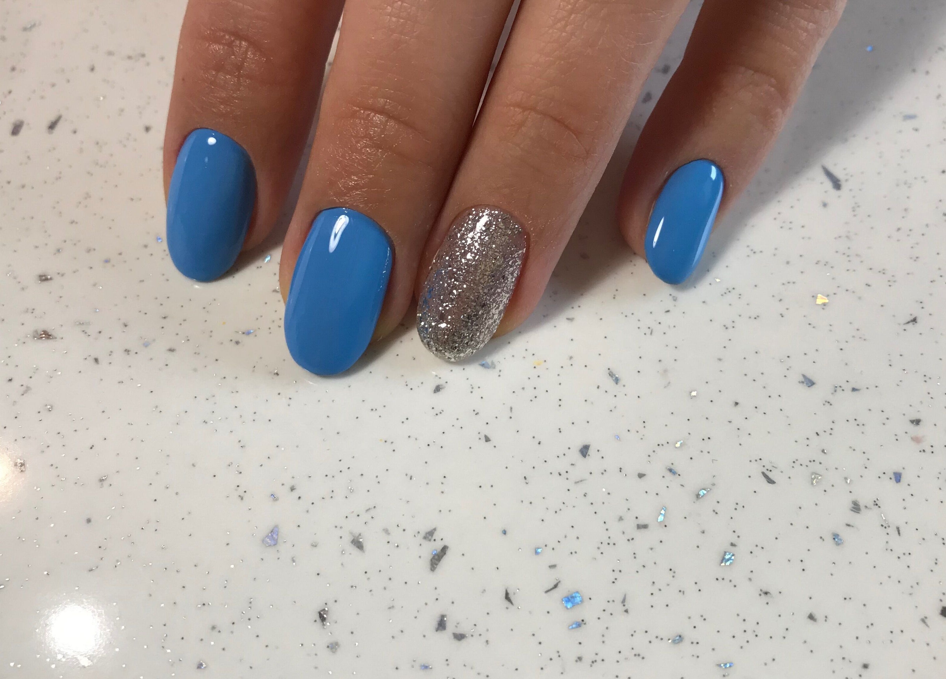 Stylish blue and glitter nail design at Amour Nails Midtown, New York, New York, US.