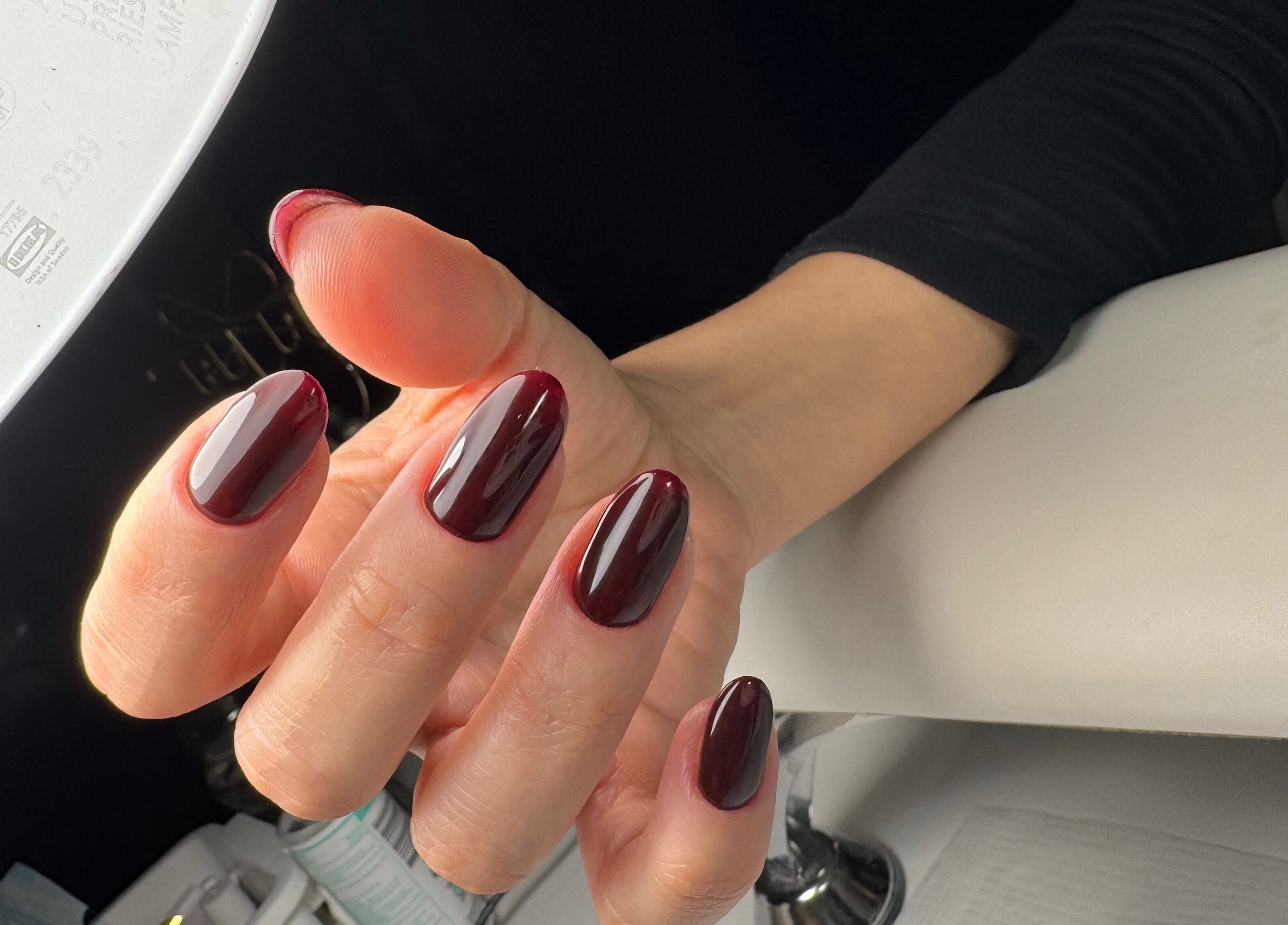 Dark red manicured nails with a glossy finish at Amour Nails Midtown, New York, New York, US.