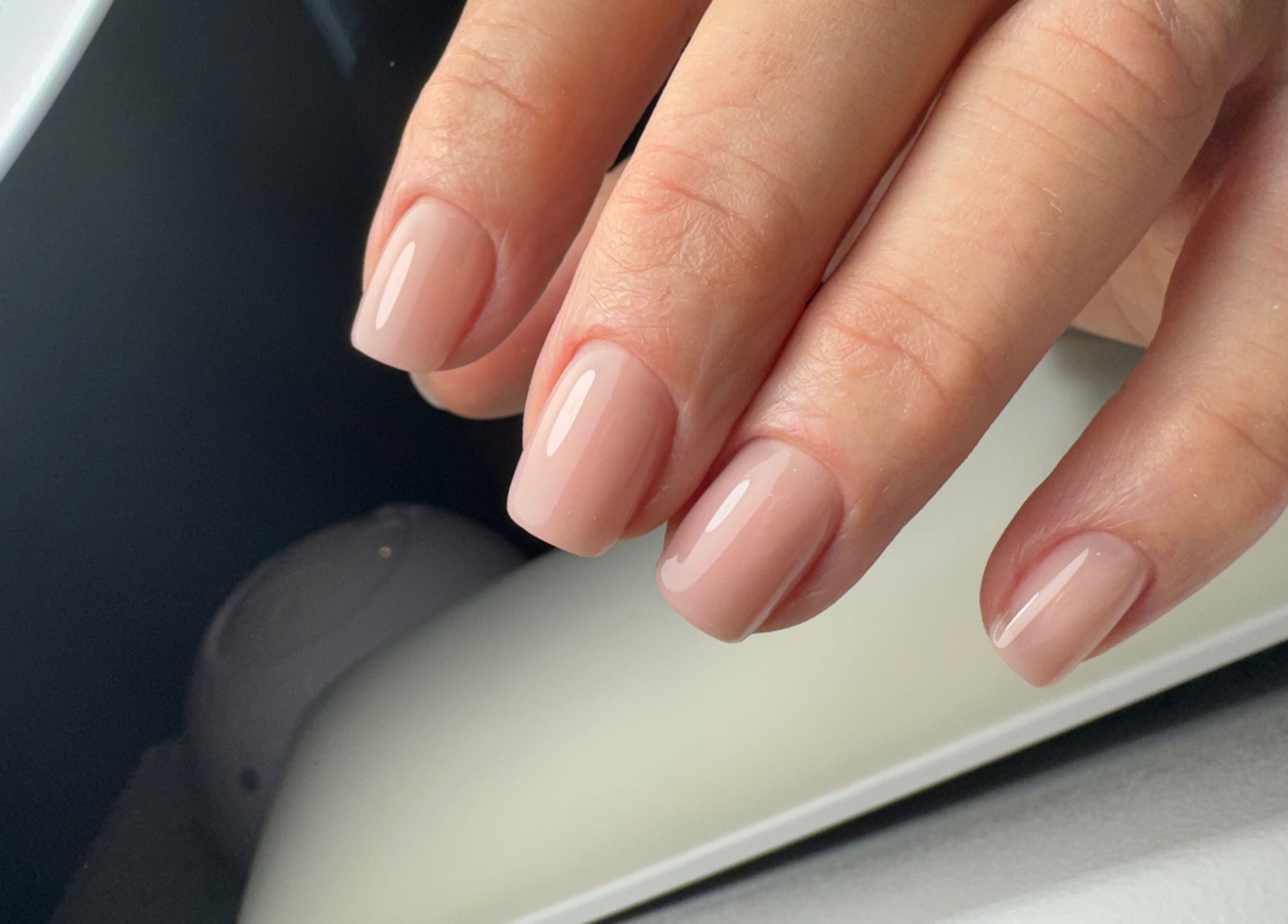 Elegant nude manicure at Amour Nails Midtown, New York, New York, US, showcasing glossy nail finish.