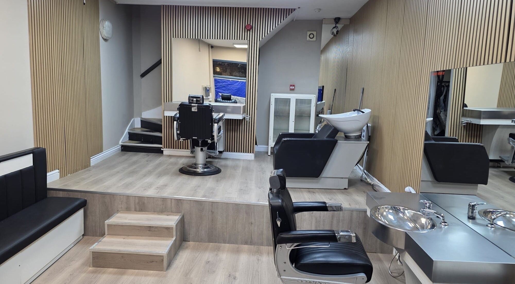 Modern salon interior at Studio Cotham, featuring sleek chairs and mirrors, Bristol, England, GB.