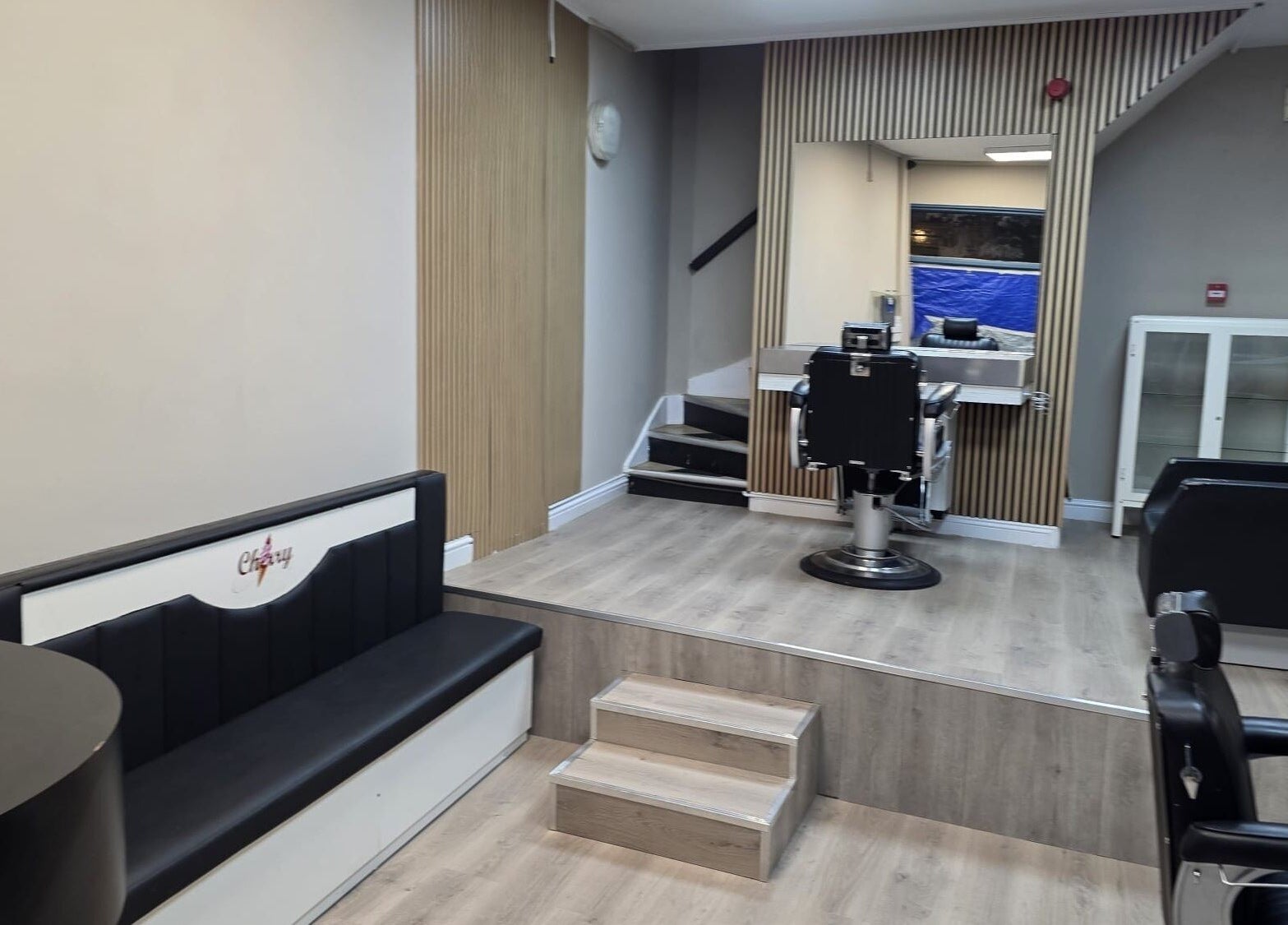 Modern salon interior at Studio Cotham, Bristol, England, GB, featuring chic seating and styling stations.