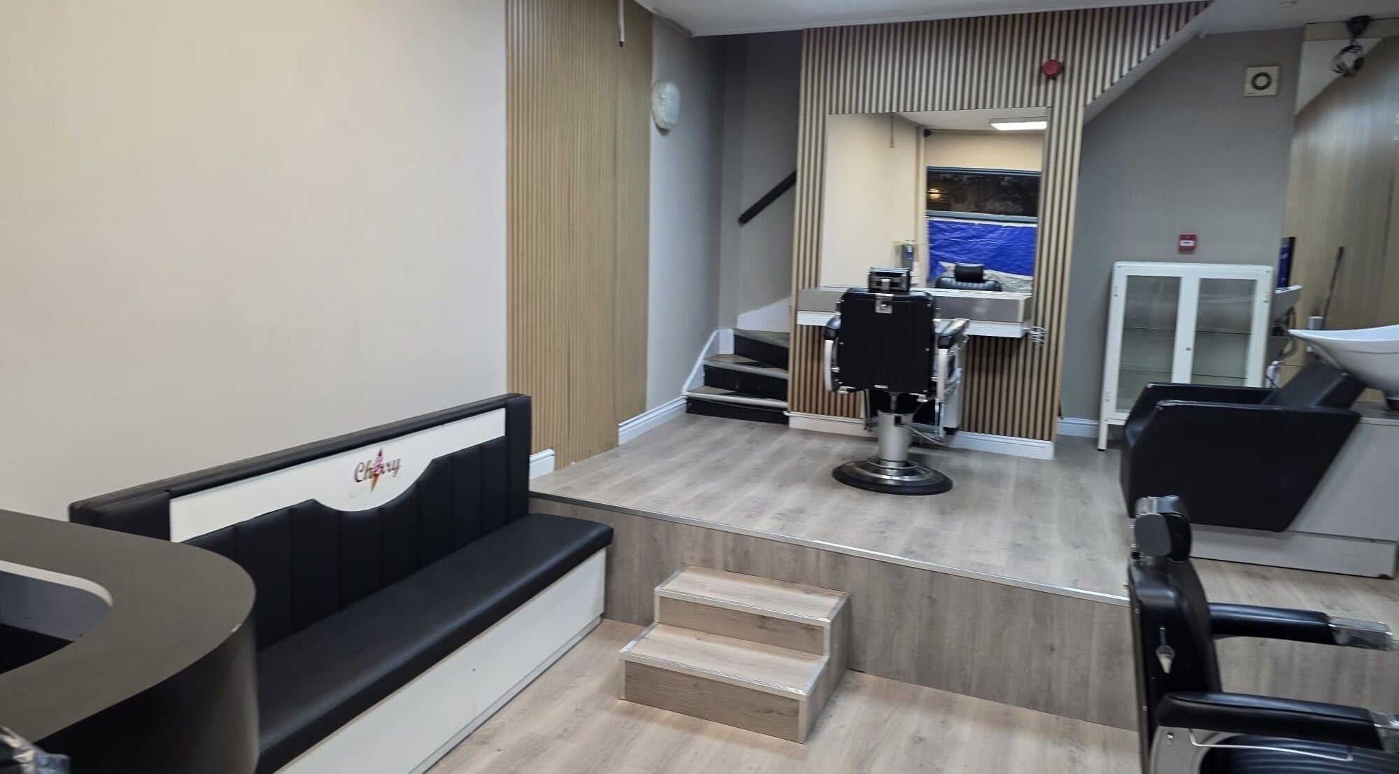 Modern salon interior at Studio Cotham, Bristol, England, GB, featuring chic seating and styling stations.