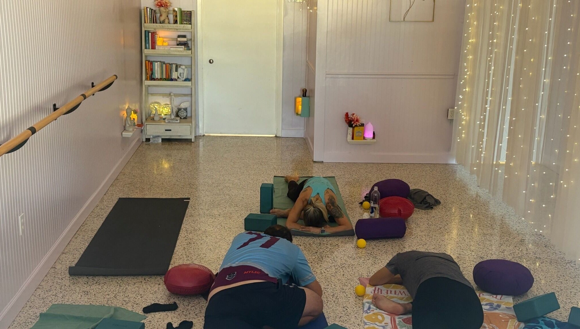 Relaxing yoga class at SoulVival Wellness, Merritt Island, Florida, US with ambient lighting and meditation props.