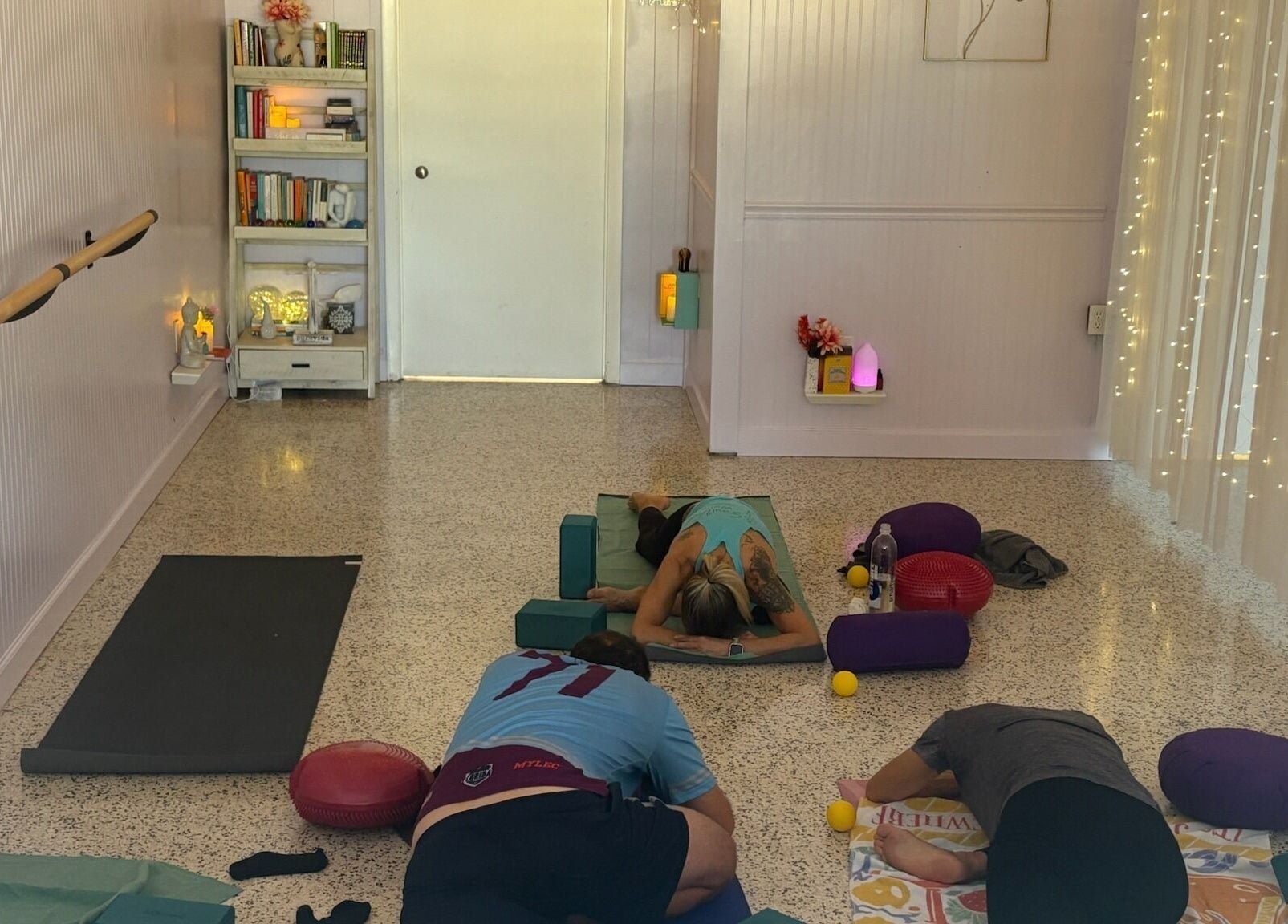 Relaxing yoga class at SoulVival Wellness, Merritt Island, Florida, US with ambient lighting and meditation props.