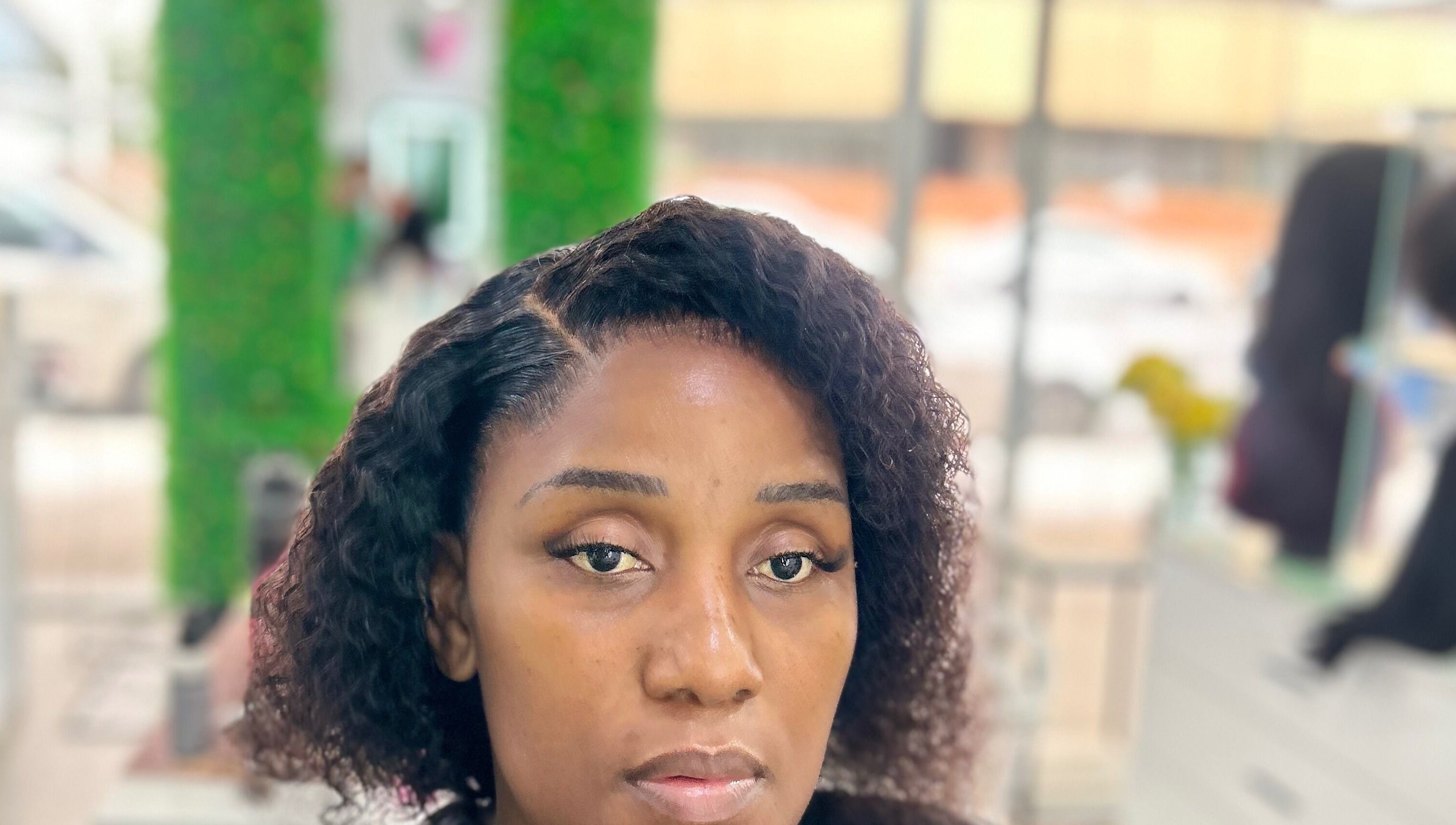 Client at Nathari Beauty Studio in Durban, ZA with styled hair and makeup reflecting elegance.