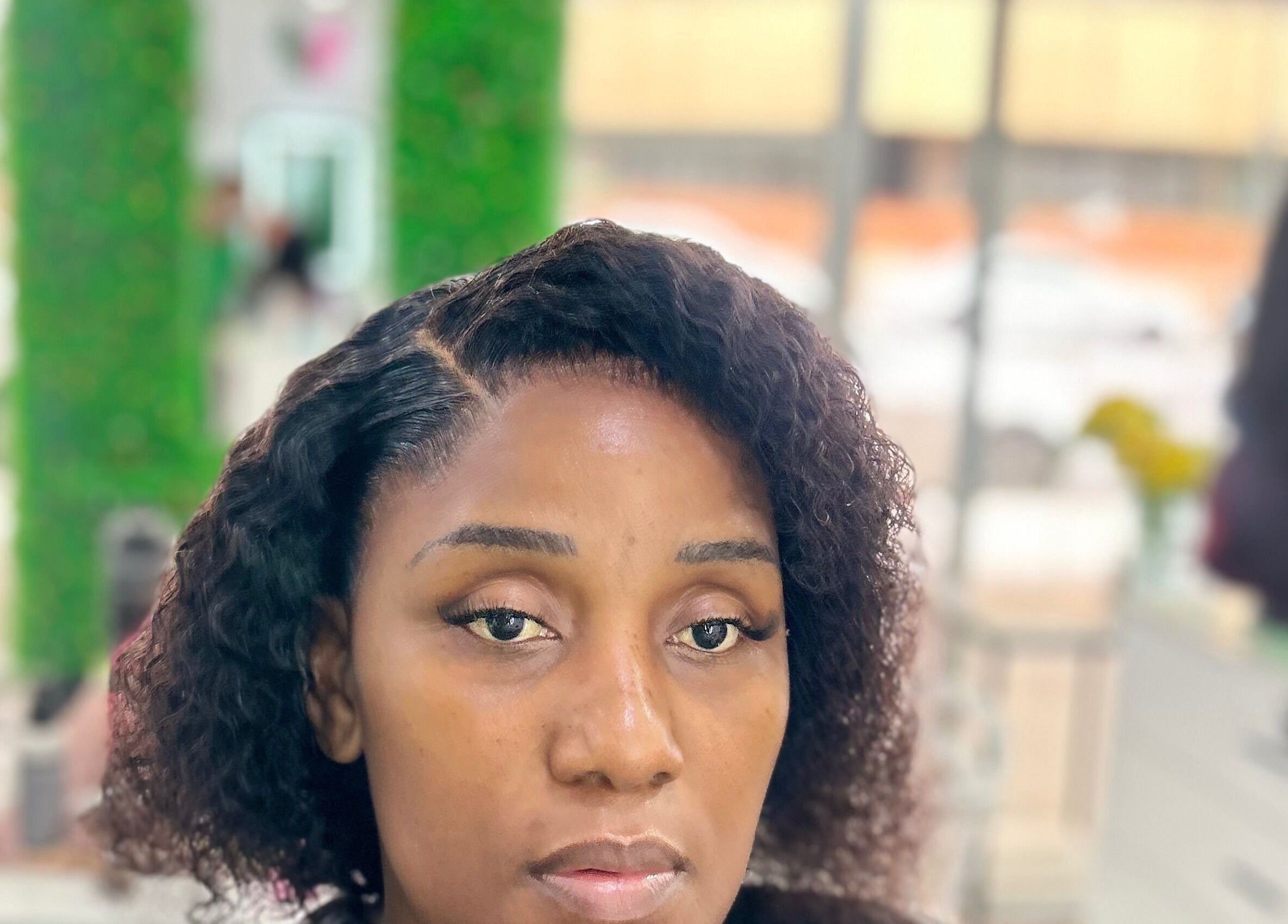 Client at Nathari Beauty Studio in Durban, ZA with styled hair and makeup reflecting elegance.