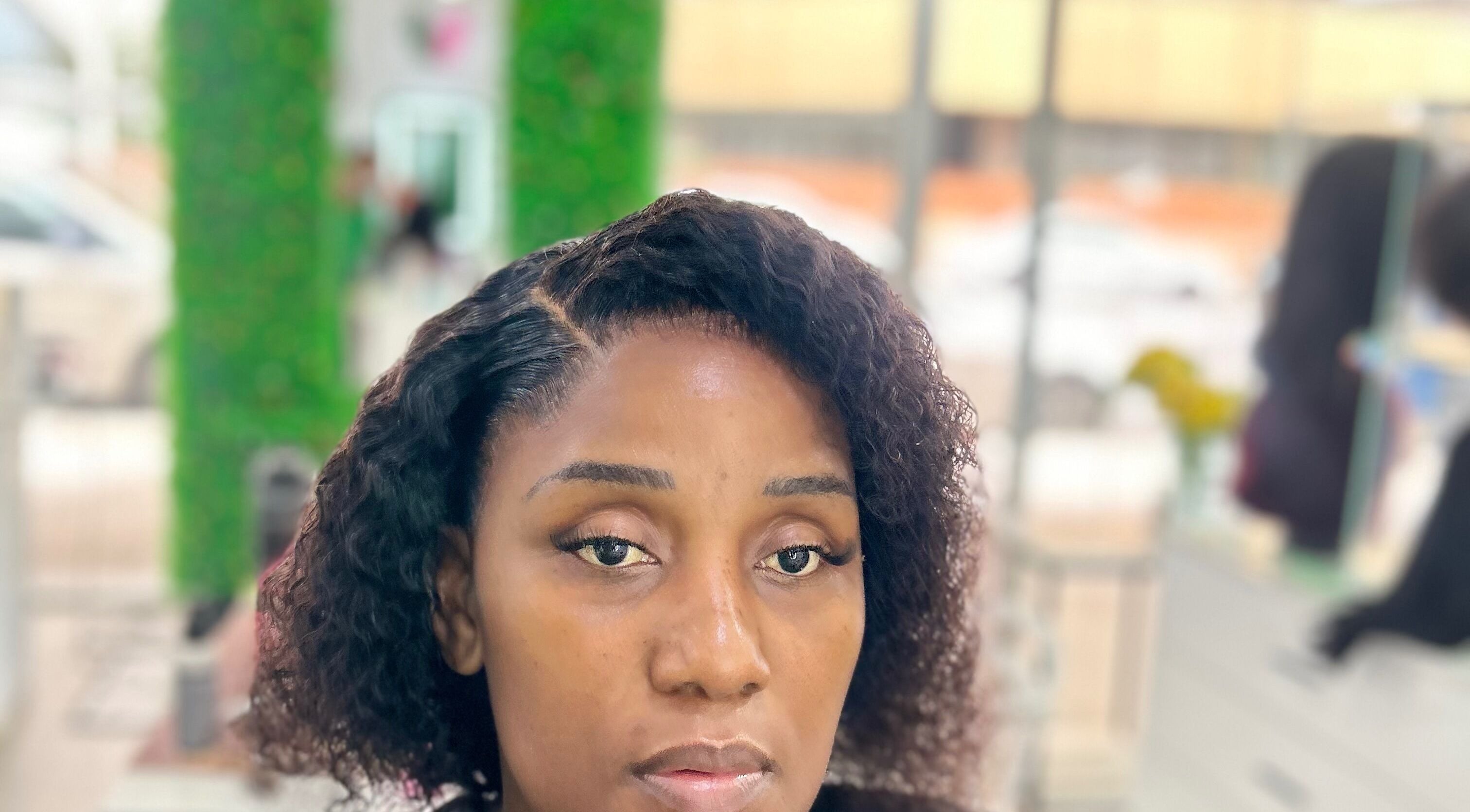 Client at Nathari Beauty Studio in Durban, ZA with styled hair and makeup reflecting elegance.