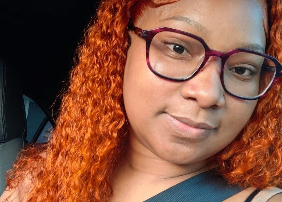 Close-up of a woman with vibrant curly orange hair at Nathari Beauty Studio, Durban, ZA.