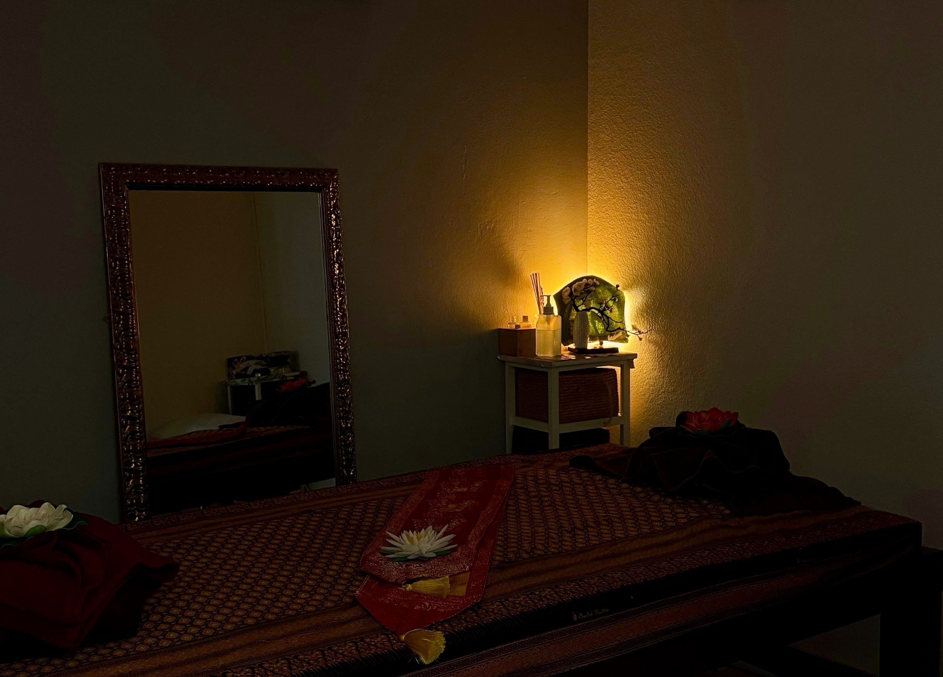 Relaxing massage room at Oil Coco Thaï, Genève, Genève, CH with warm lighting and elegant decor.
