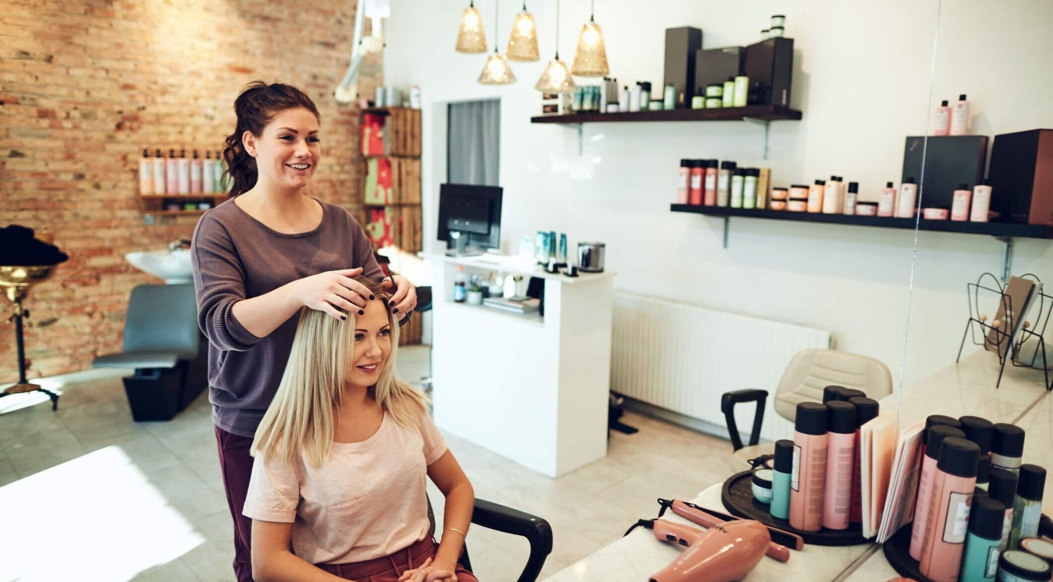 Cabeleireira estiliza cabelo de cliente no salão Lorena Lorena em Santa Catarina, Santa Catarina, BR.