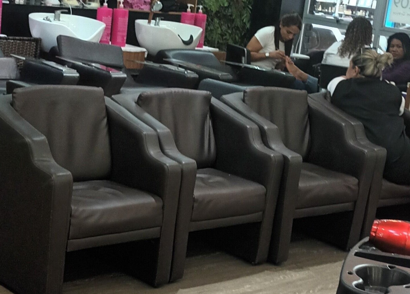 Interior do Carolina studio93 em São Paulo, BR, com poltronas elegantes e estação de beleza ativa.