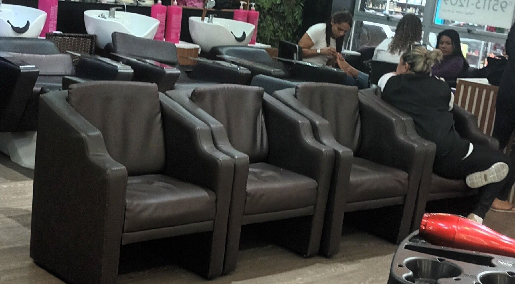 Interior do Carolina studio93 em São Paulo, BR, com poltronas elegantes e estação de beleza ativa.