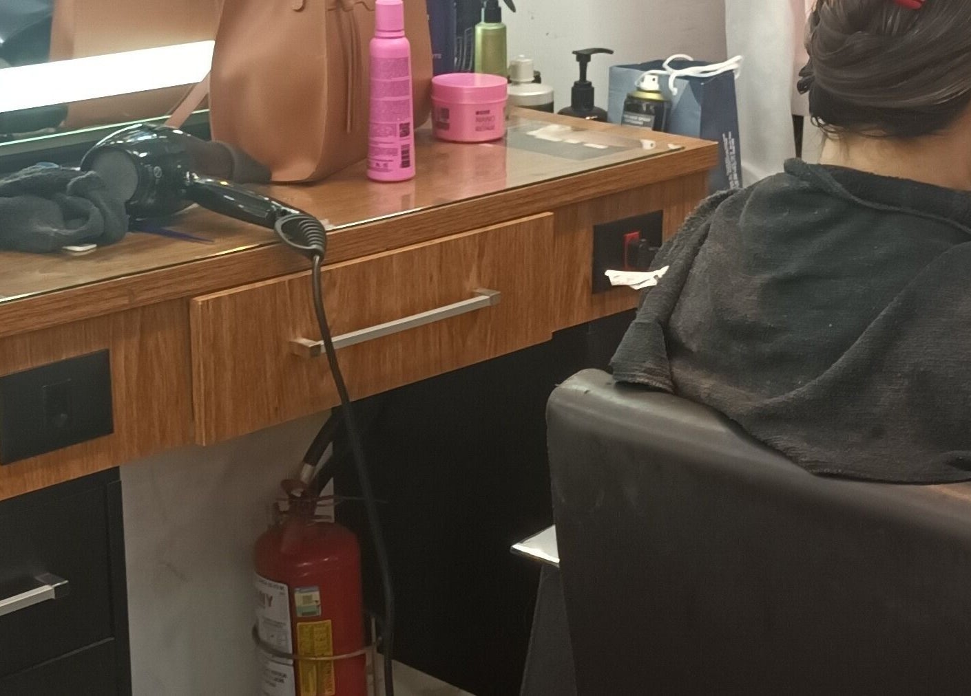 Estação de cabeleireiro em Carolina studio93, São Paulo, SP, BR com secador e produtos de beleza.