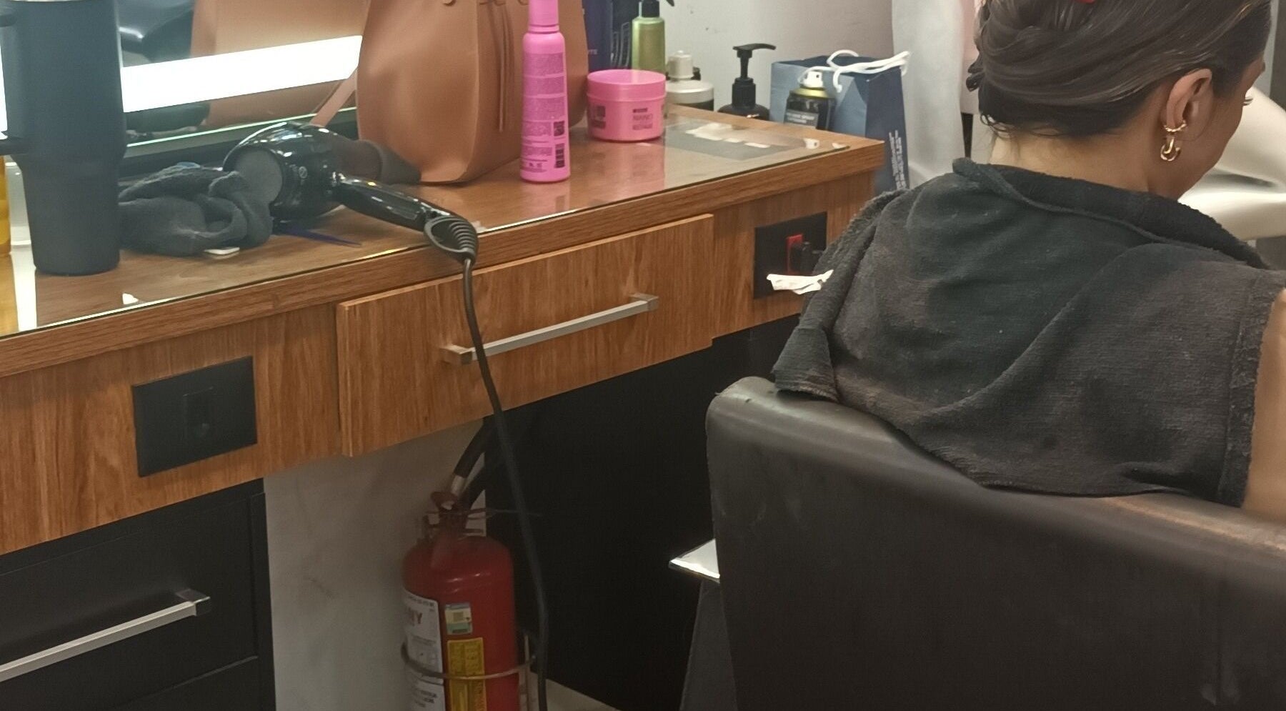 Estação de cabeleireiro em Carolina studio93, São Paulo, SP, BR com secador e produtos de beleza.