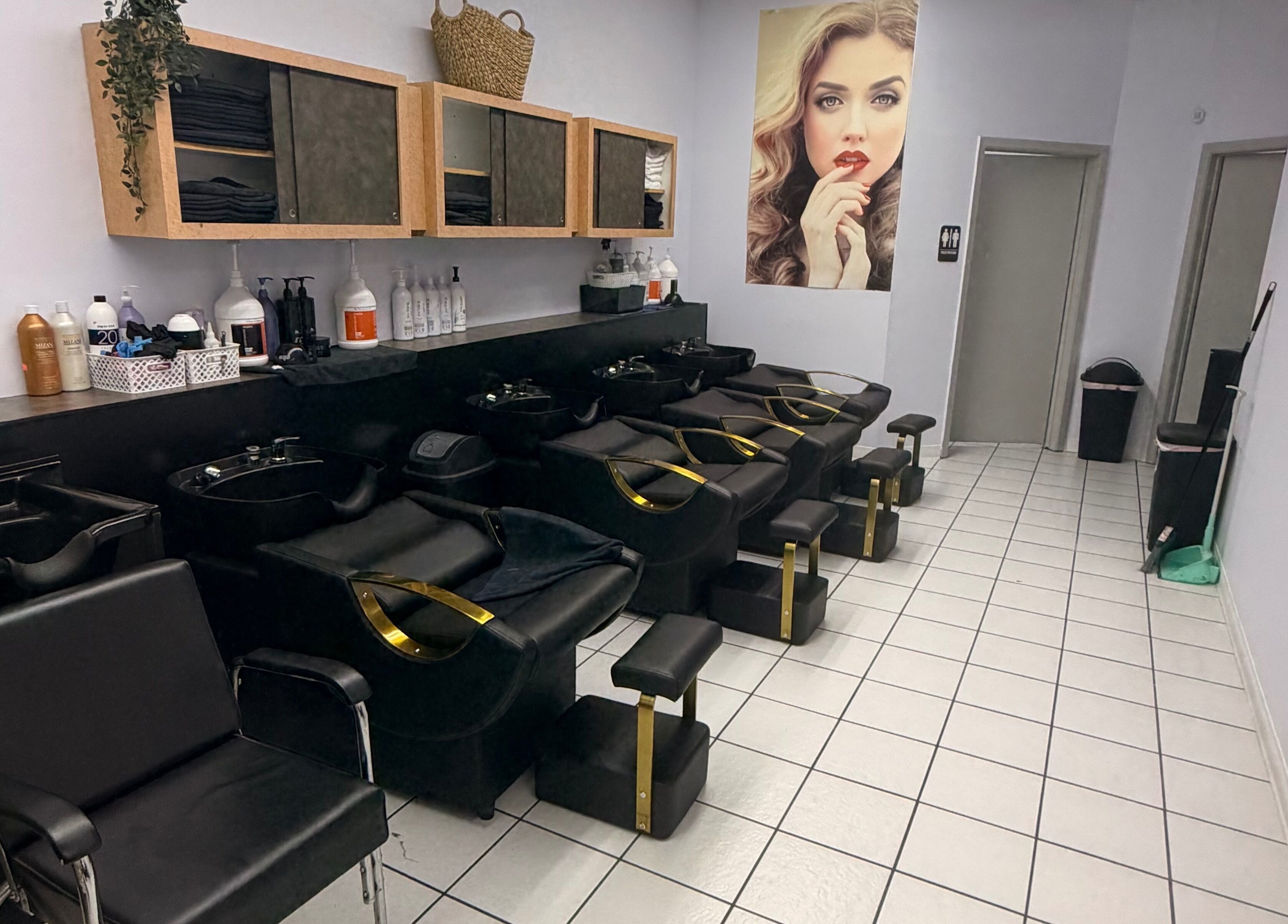 Elegant wash station at Jasmine’s beauty salon, Houston, Texas, US, featuring modern black chairs.