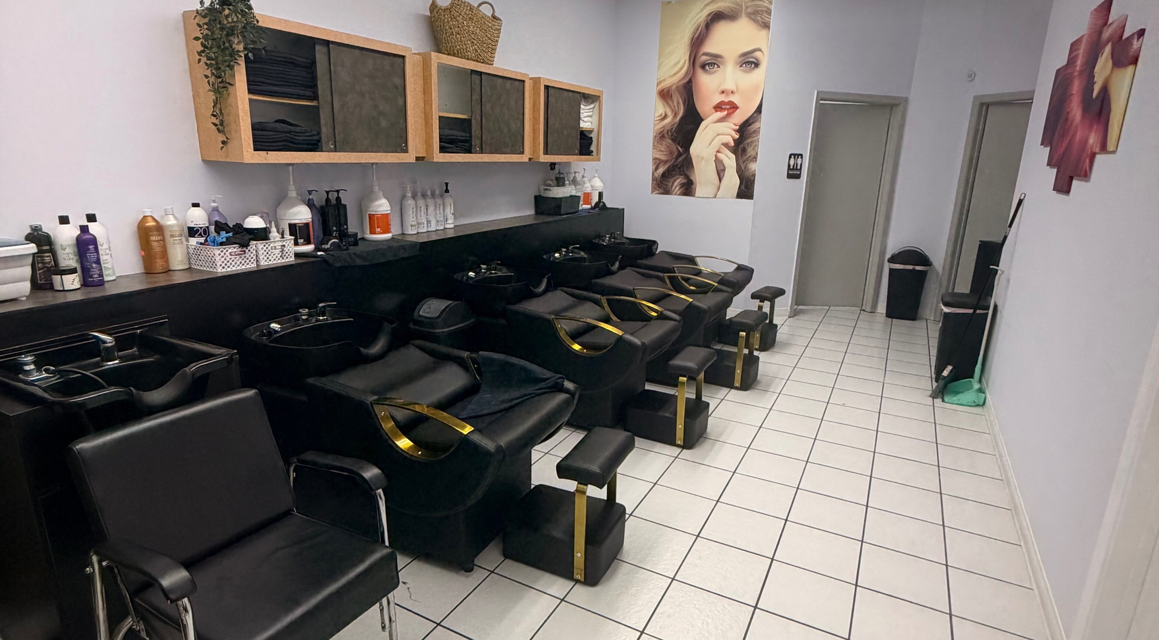 Elegant wash station at Jasmine’s beauty salon, Houston, Texas, US, featuring modern black chairs.