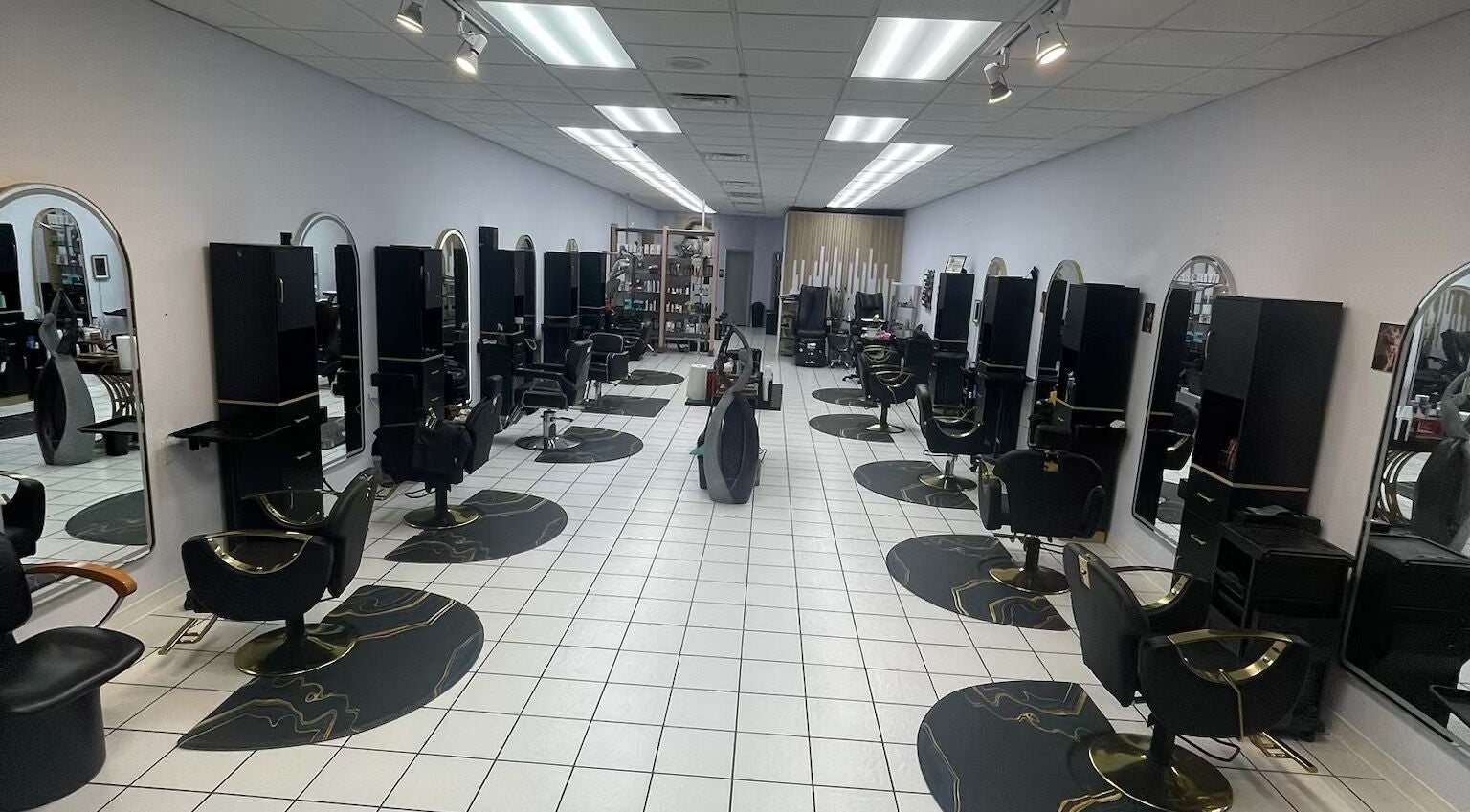 Spacious interior of Jasmine’s Beauty Salon, Houston, Texas, US, featuring modern styling stations and sleek black chairs.