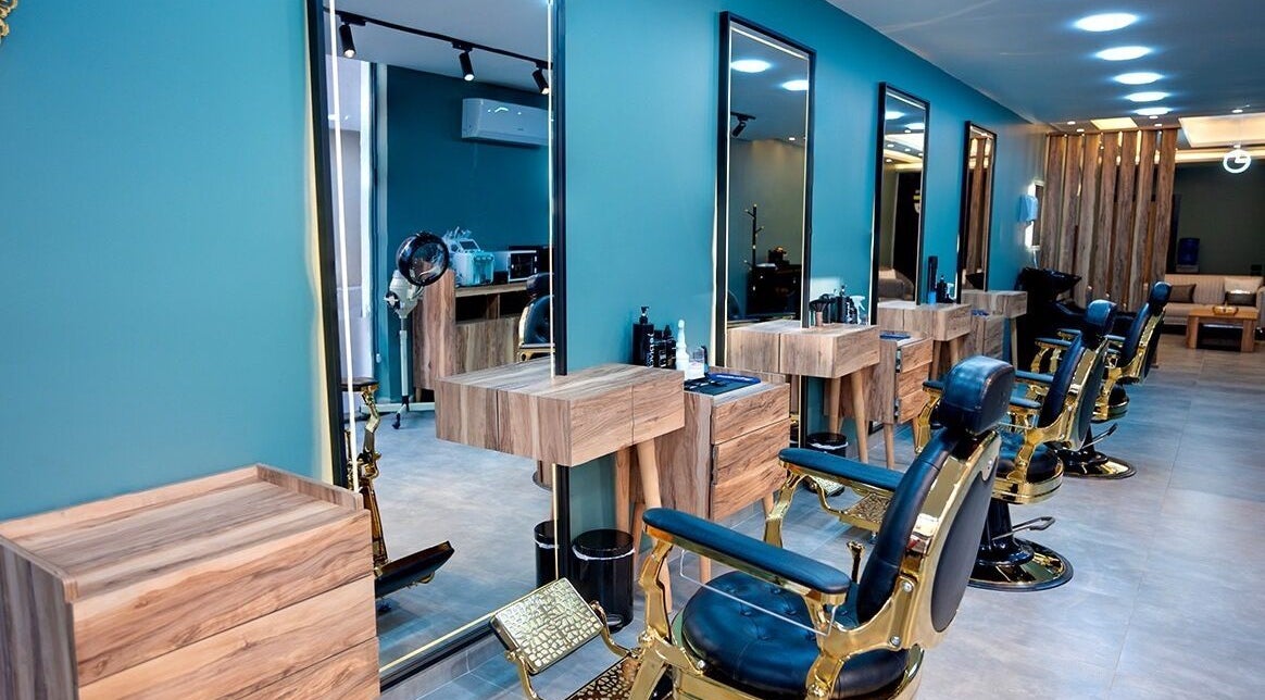 داخل صالون LE ELITE الفاخر في عمان، عمان، JO بتصميم خشبي عصري ومقاعد مريحة.