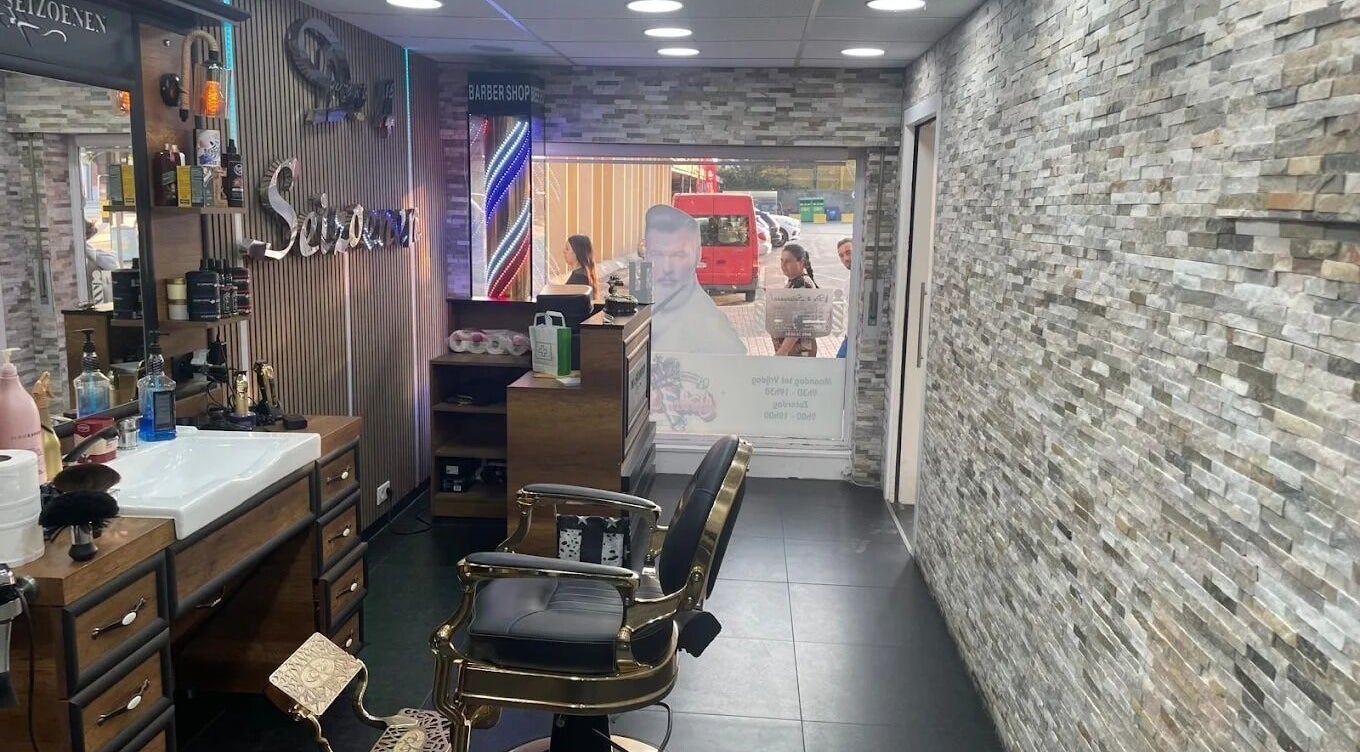 Intérieur stylé de De4seizoenen à Halle, Vlaanderen, BE avec fauteuil barbier et décor moderne.