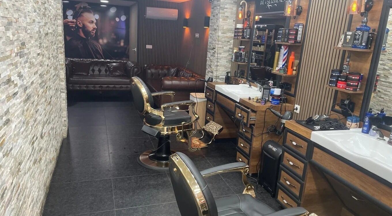Salon moderne chez De4seizoenen, Halle, Vlaanderen, BE avec fauteuils de barbier élégants et cadres luxueux.