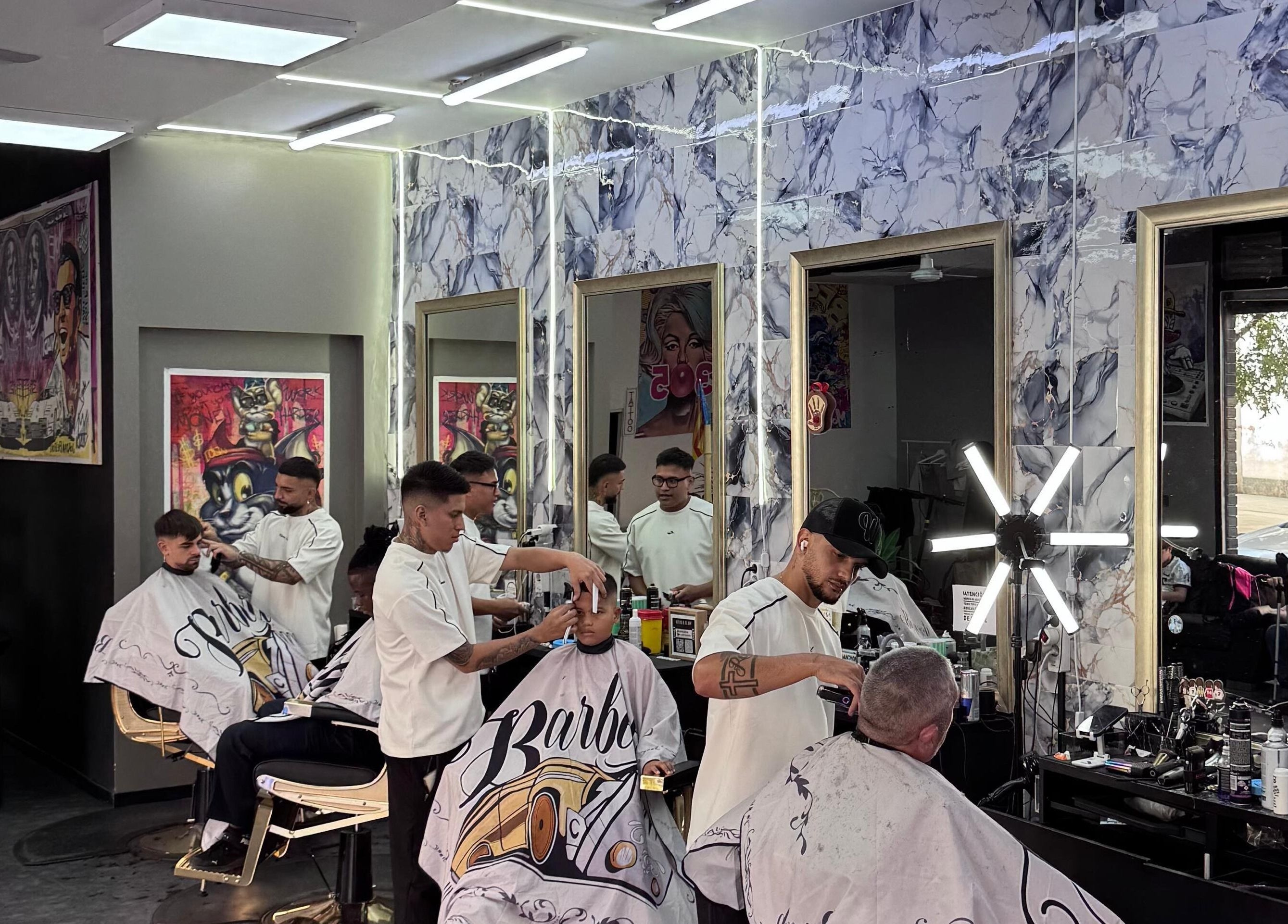 Interior de 305 Barberia en València, Comunidad Valenciana, ES, barberos estilizando clientes.