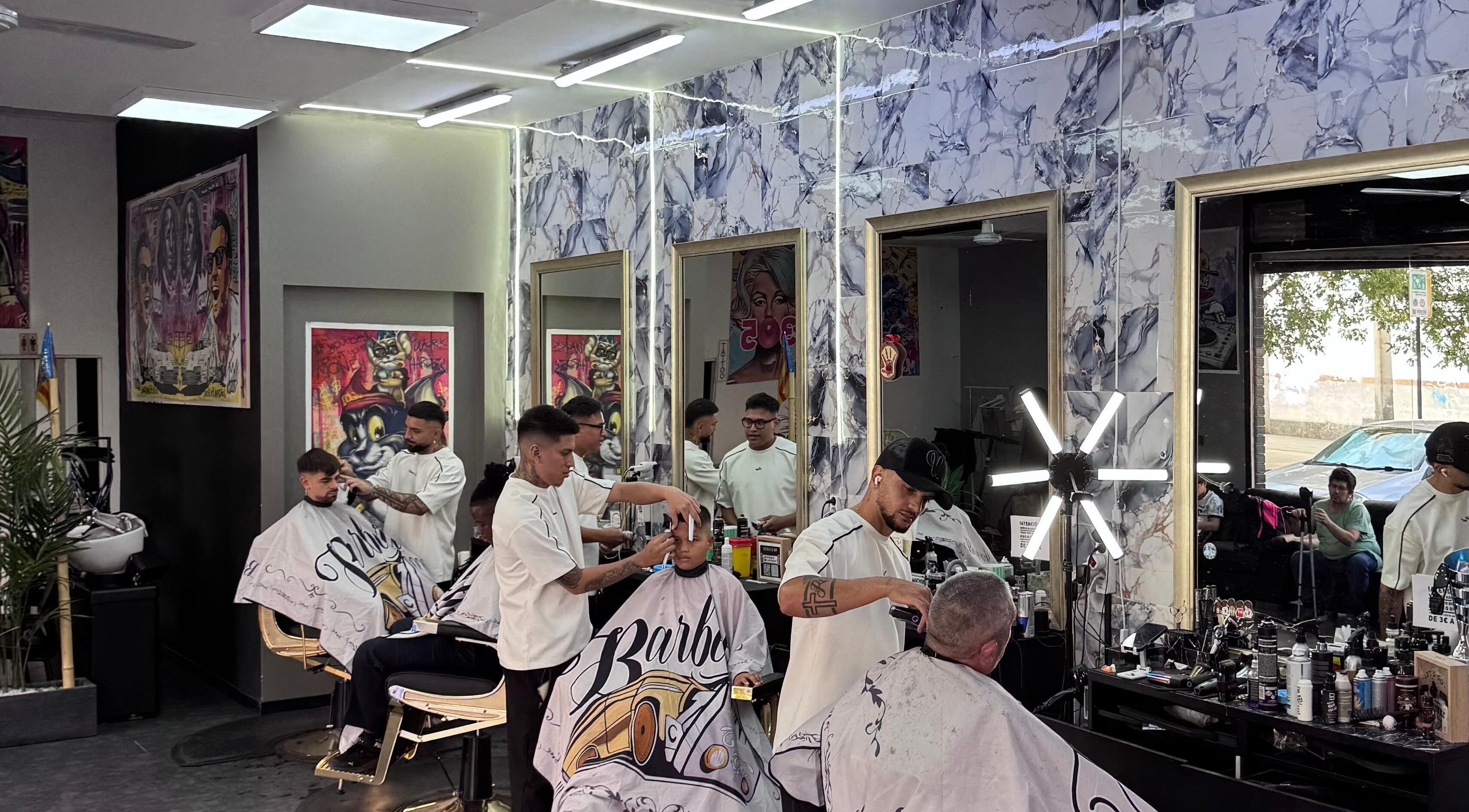 Interior de 305 Barberia en València, Comunidad Valenciana, ES, barberos estilizando clientes.