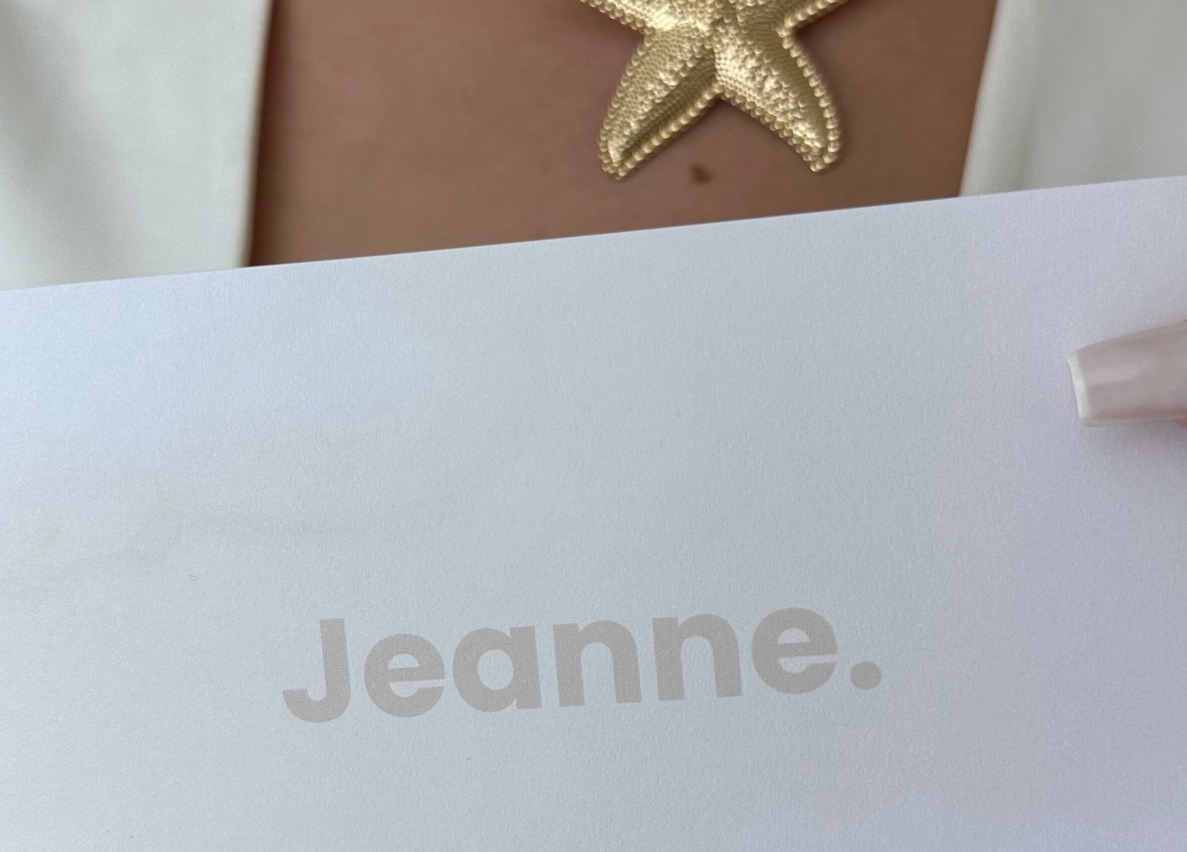 Collier étoile dorée tenu à Jeanne, Amiens, Hauts-de-France, FR.