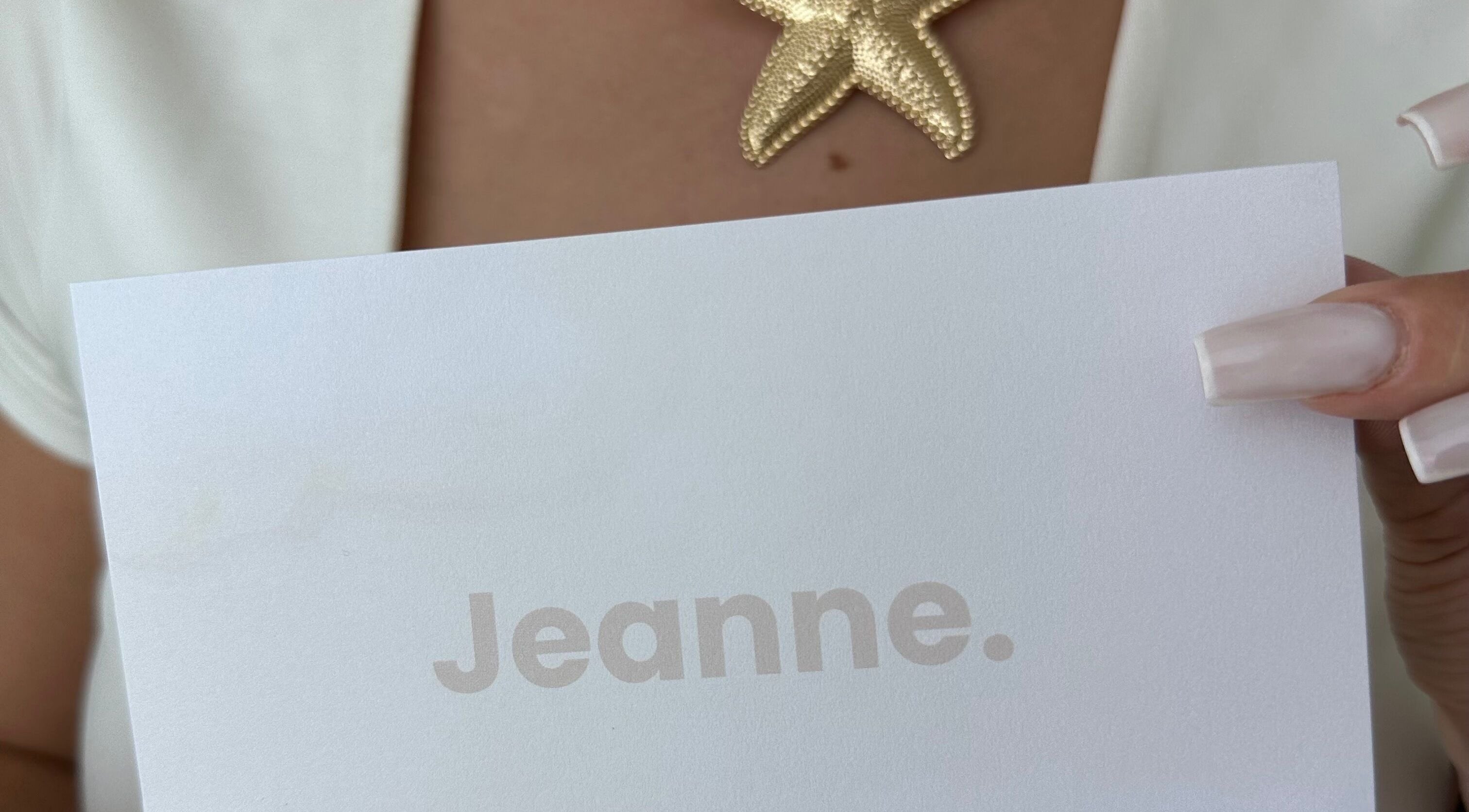 Collier étoile dorée tenu à Jeanne, Amiens, Hauts-de-France, FR.