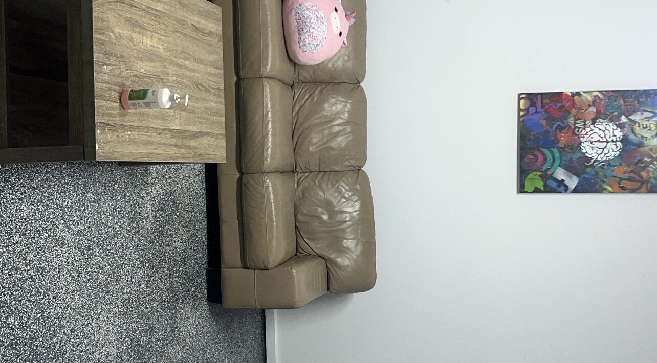 Chic lounge at Sultan Lashes, Melbourne, Victoria, AU featuring a plush sofa and modern decor.