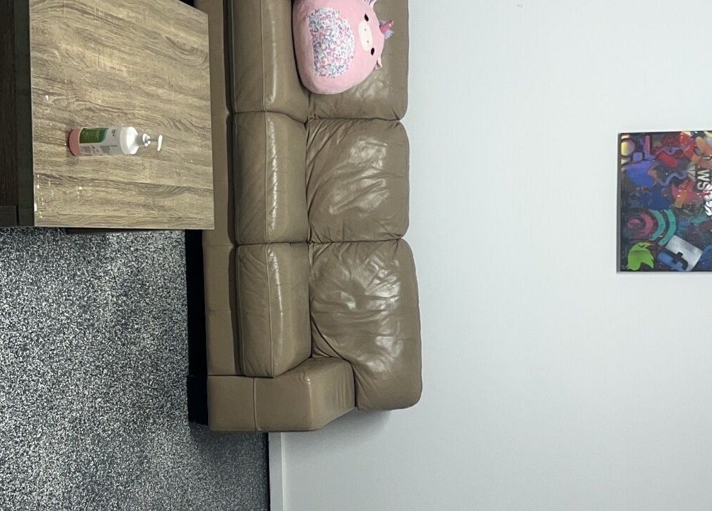 Comfy brown couch with colorful pillow at Sultan Lashes, Melbourne, Victoria, AU.