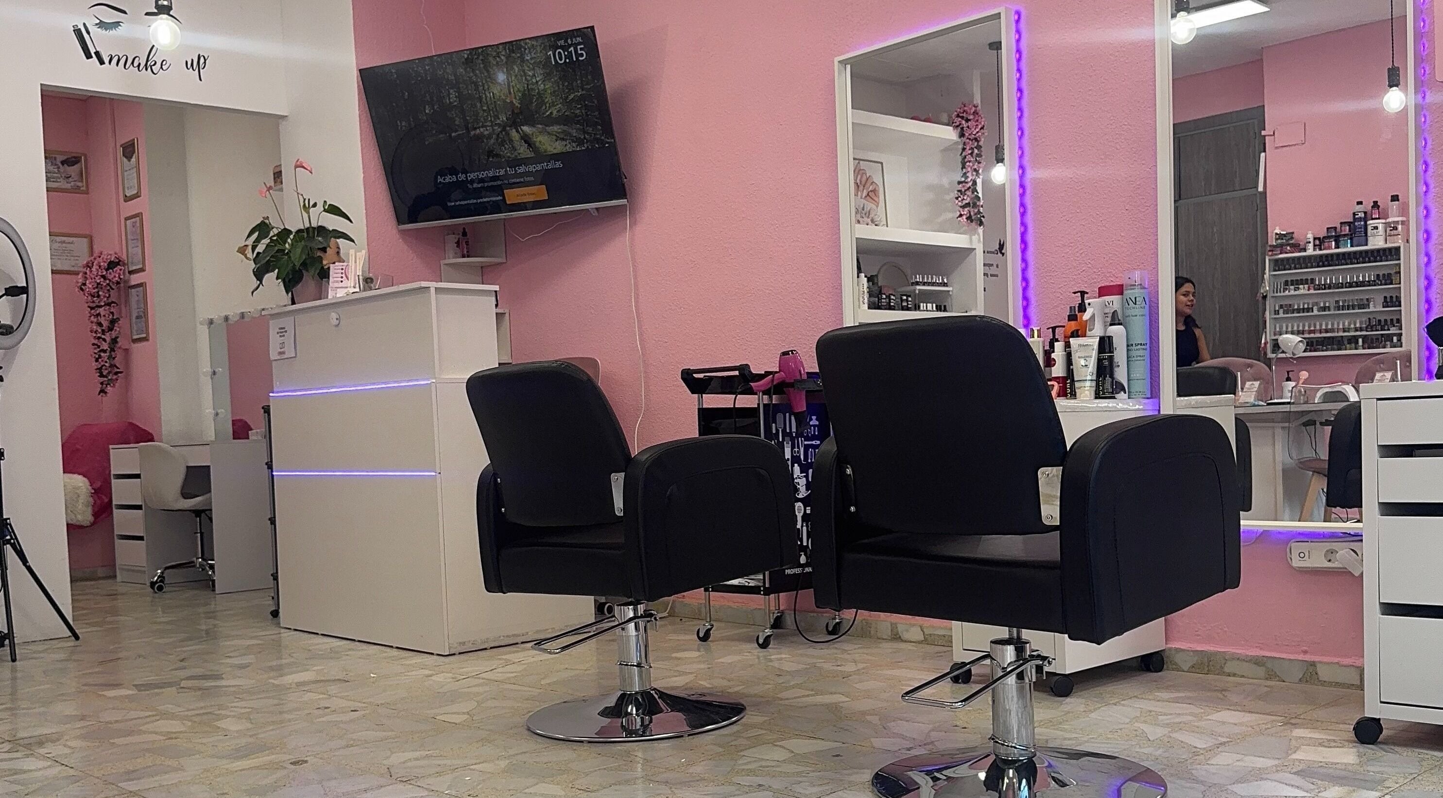 Interior moderno de Centro De Belleza Pifferrer en Alcalá De Henares, Comunidad De Madrid, ES, con sillas negras y espejo iluminado.