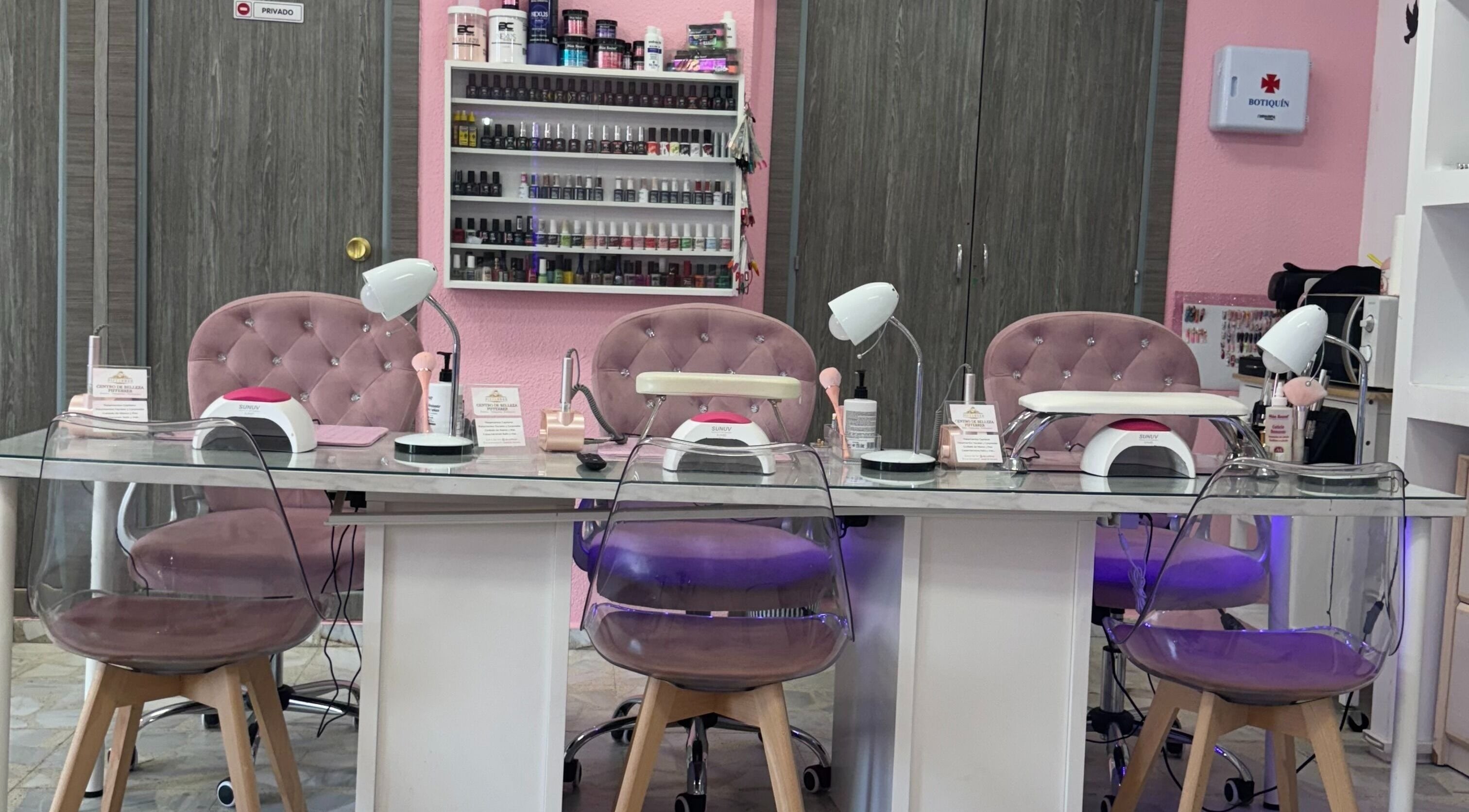 Mesa de manicura en Centro De Belleza Pifferrer, Alcalá De Henares, Comunidad De Madrid, ES, con sillas rosas.