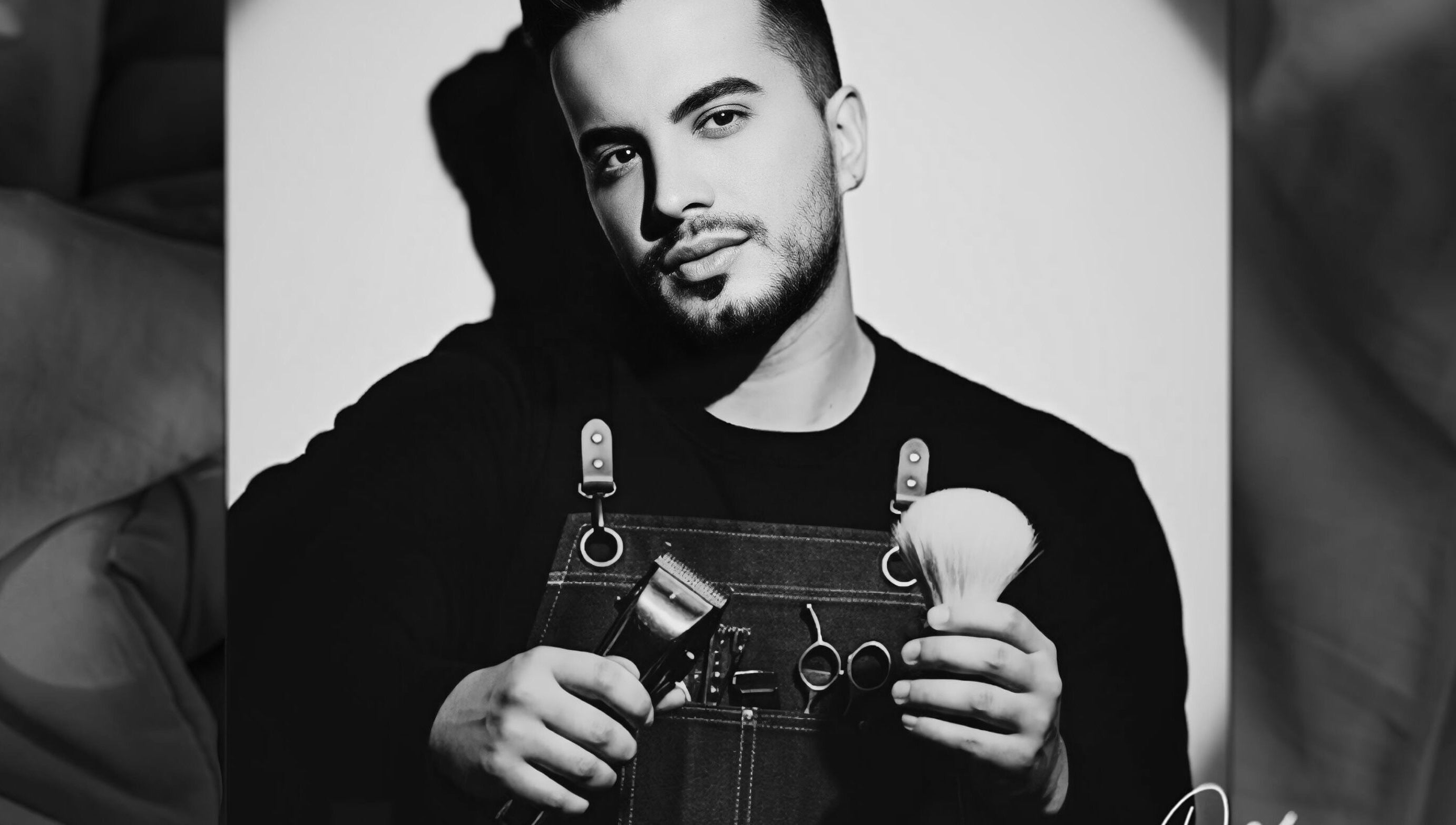 Barber at De Biasio Hair holding tools in Church, England, GB.