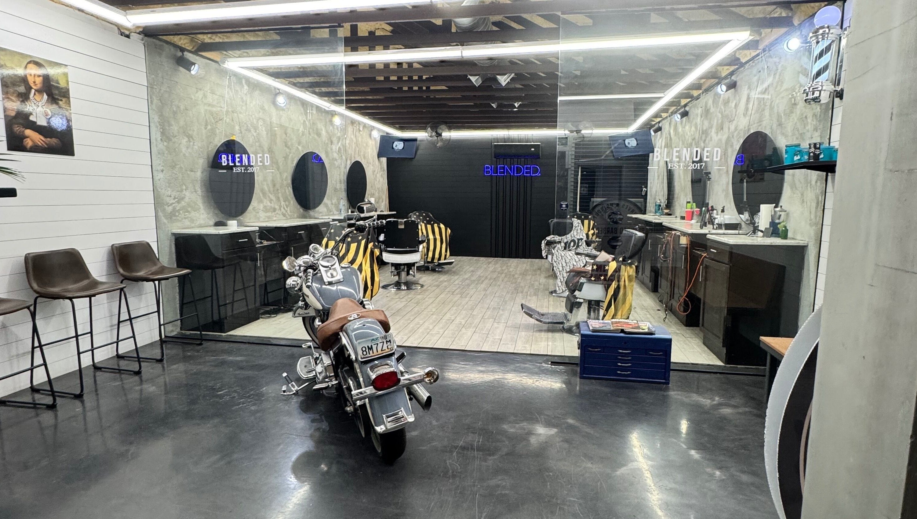 Chic interior of Rudy the barber in Phoenix, Arizona, US with modern chairs and a motorcycle centerpiece.