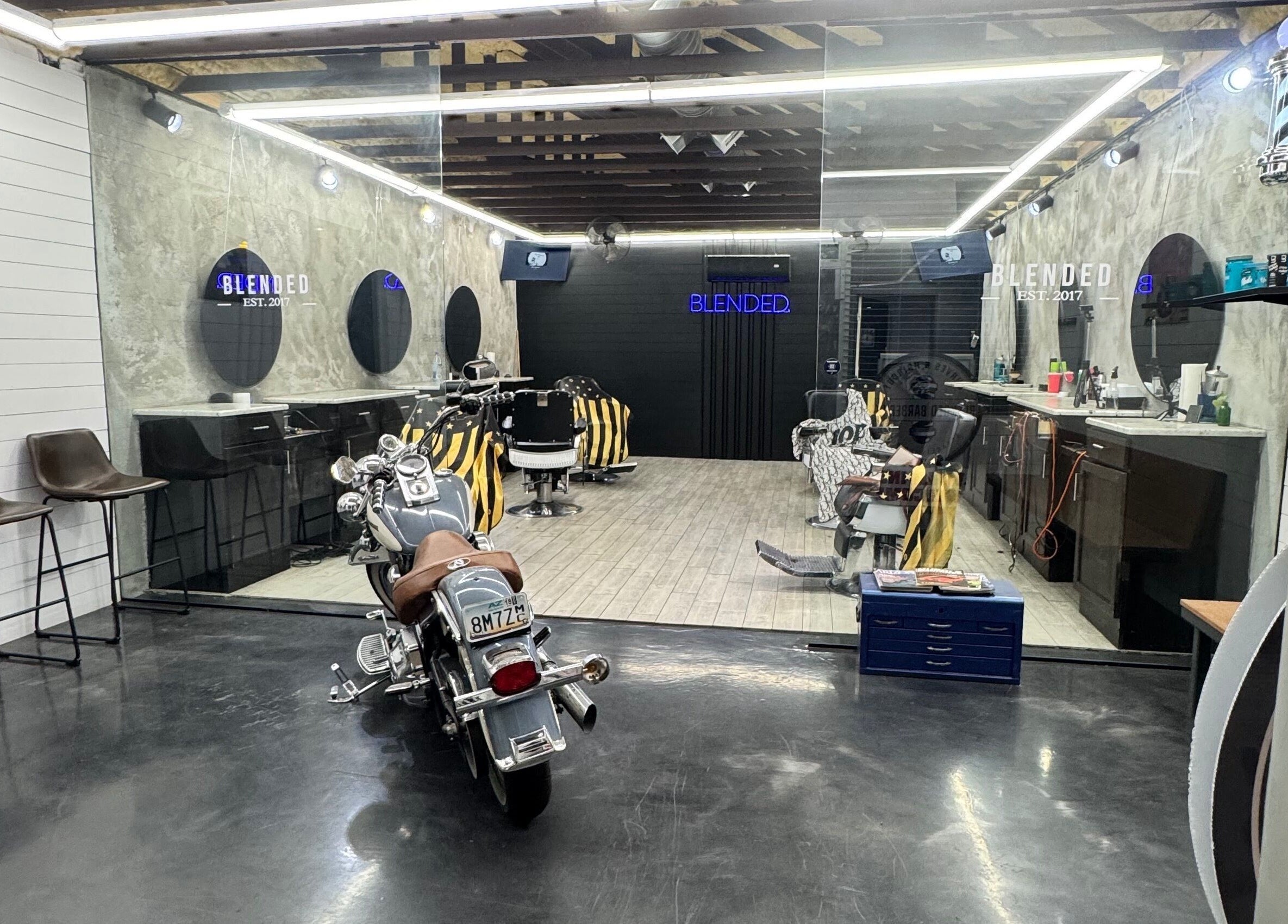 Chic interior of Rudy the barber in Phoenix, Arizona, US with modern chairs and a motorcycle centerpiece.