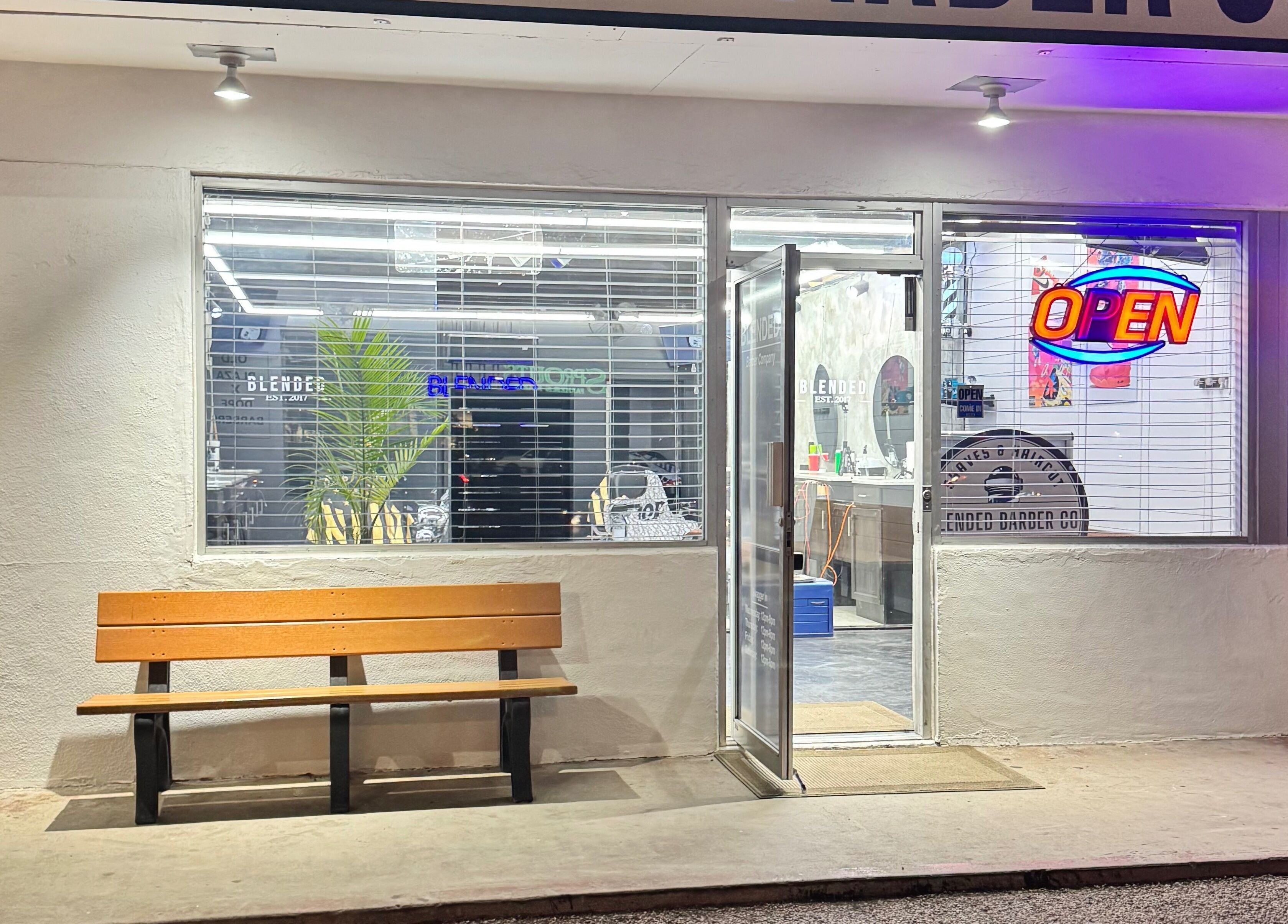 Exterior of Rudy the barber with open sign glowing in Phoenix, Arizona, US.