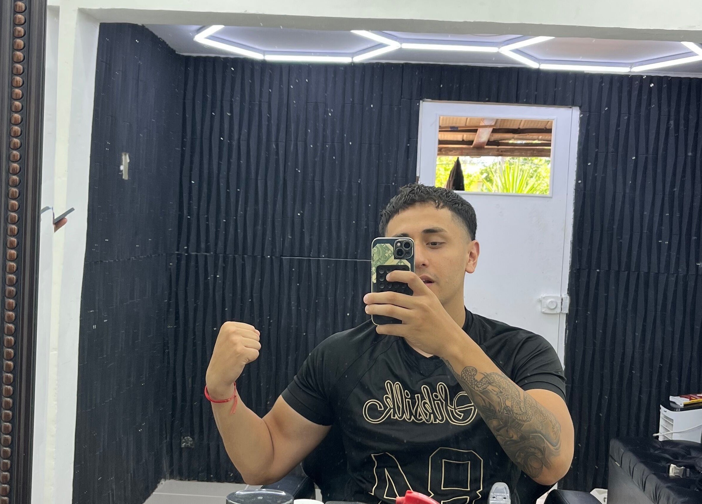 Interior de Drako Barber Studio, La Florida, Región Metropolitana, CL, con cliente frente al espejo.